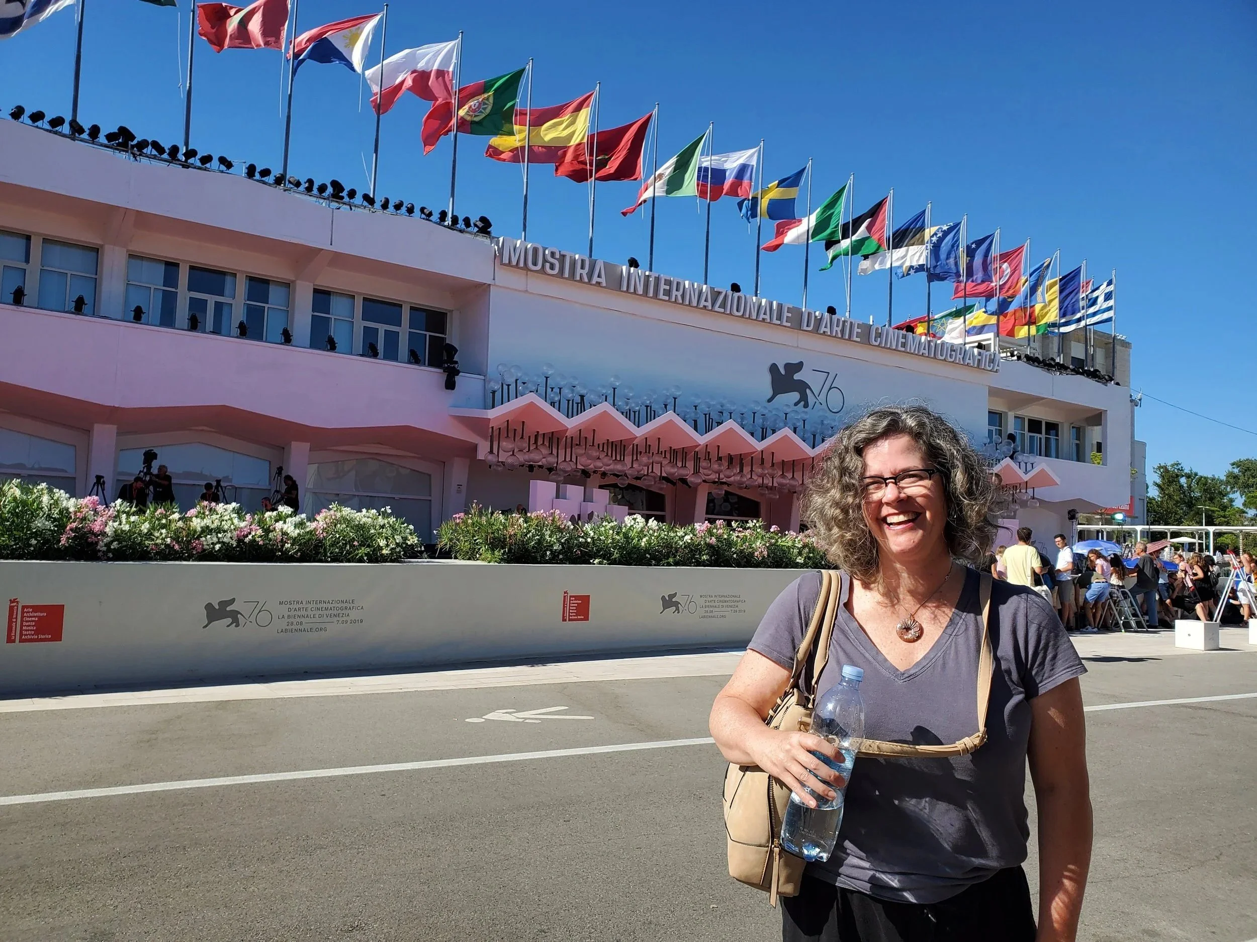 Kerry smiling standing in front of The Palazzo del Cinema on the Lido di Venezia - the main headquarters for the Venice International Film Festival.