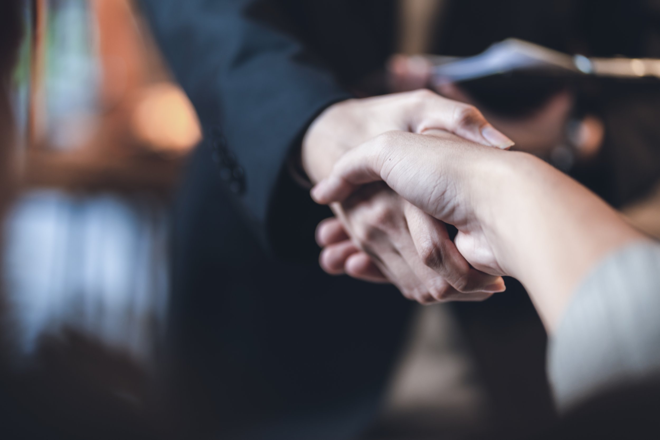 Imagen de dos personas dándose la mano, símbolo de acuerdo o saludo, en un entorno profesional.