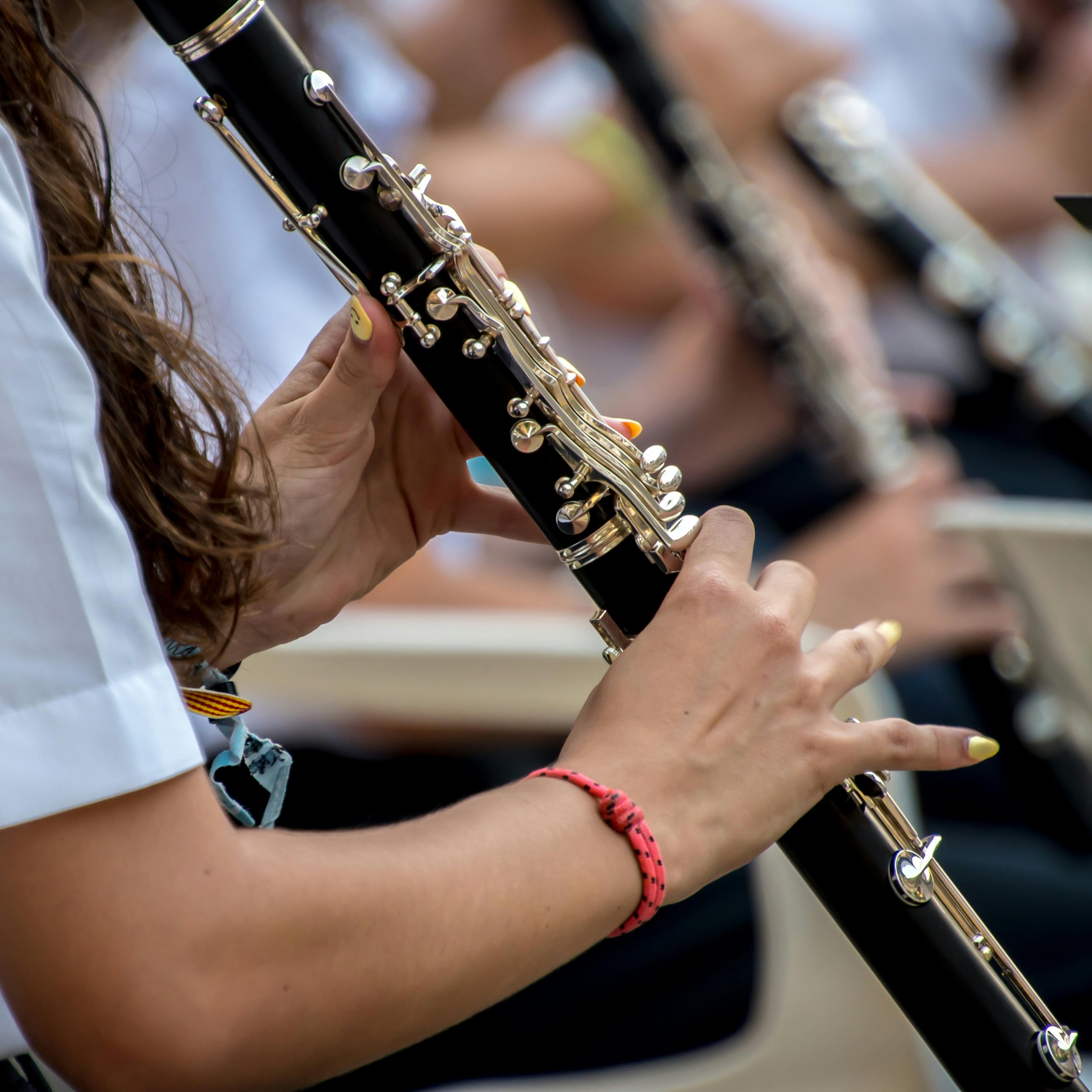 A person holding a clarinet during a group musical performance.