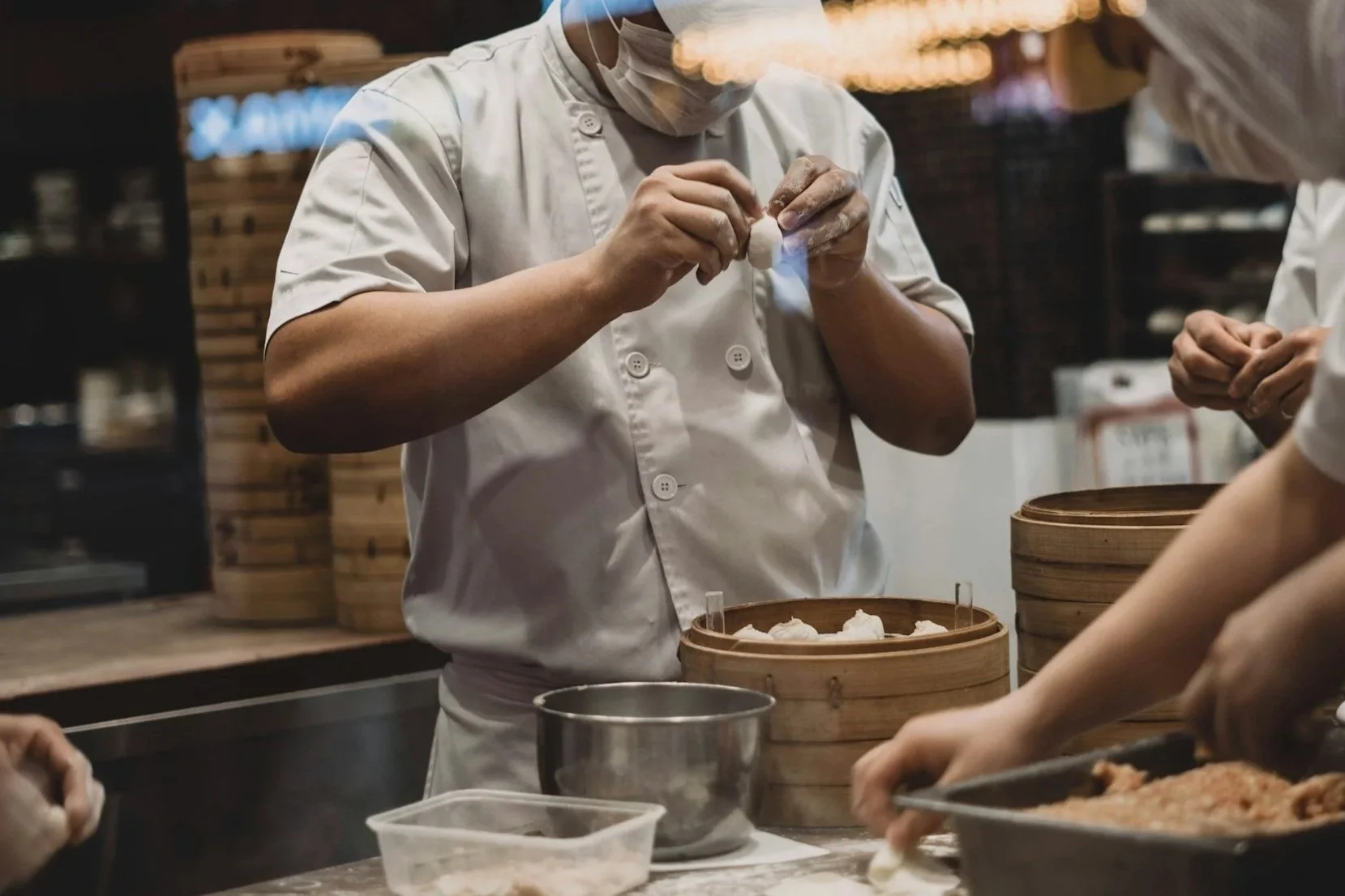 Chef preparing dumplings in a restaurant kitchen.