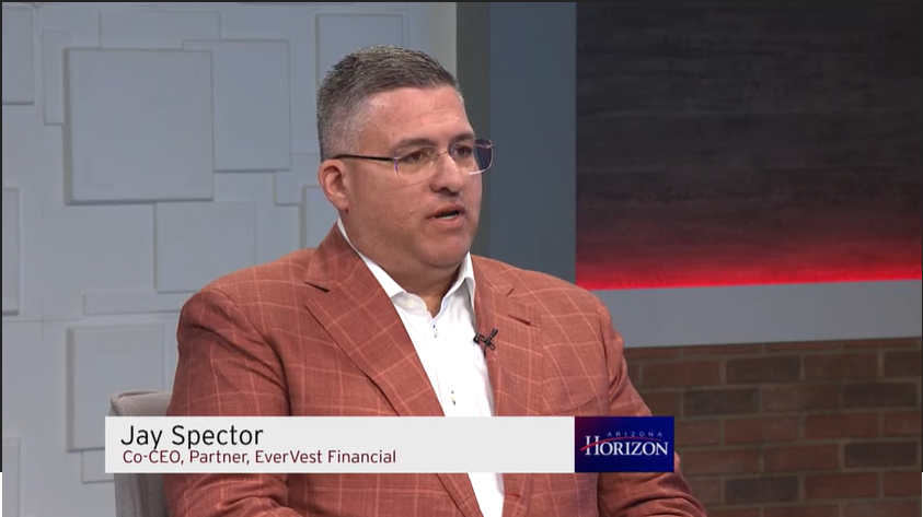Jay Spector, co-CEO and partner at EverVest Financial, wearing glasses and a brown checkered blazer, during a televised interview on Arizona Horizon.