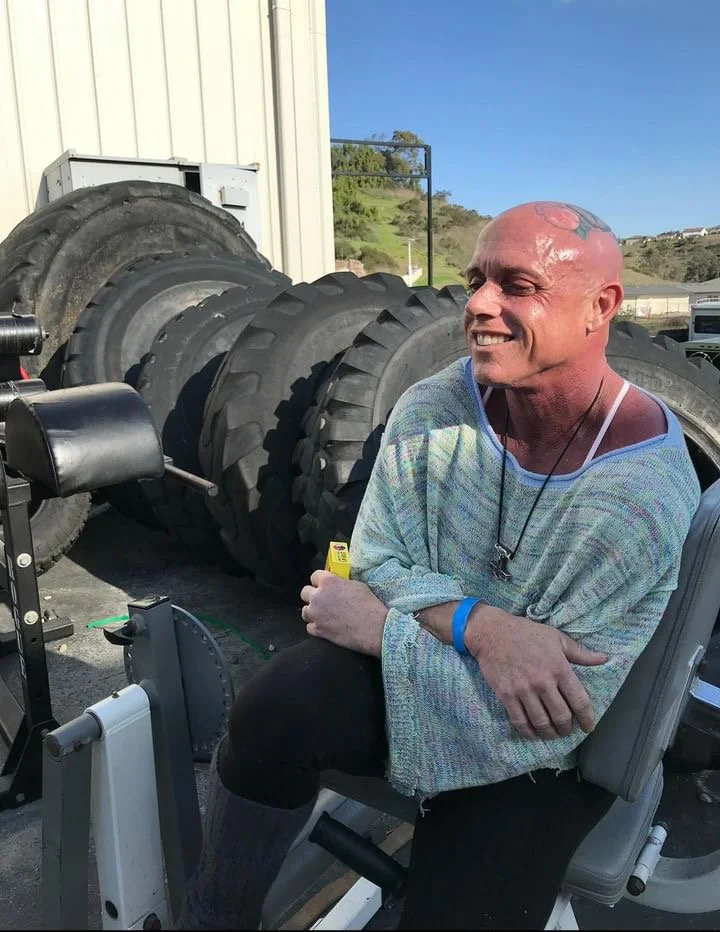 Liz Freel is smiling, while standing with her arms cross outside of Metroflex gym in Long Beach CA.