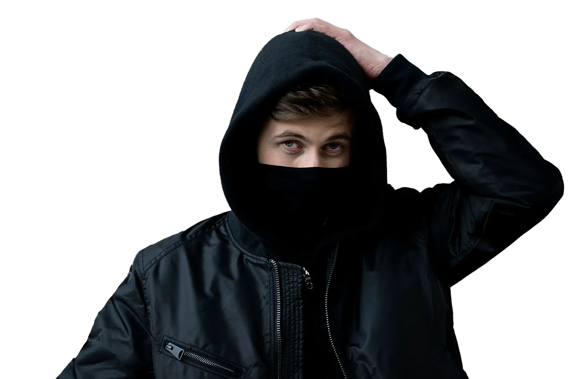 Young man wearing a black hooded jacket and face covering, with hand on his head, looking at the camera.