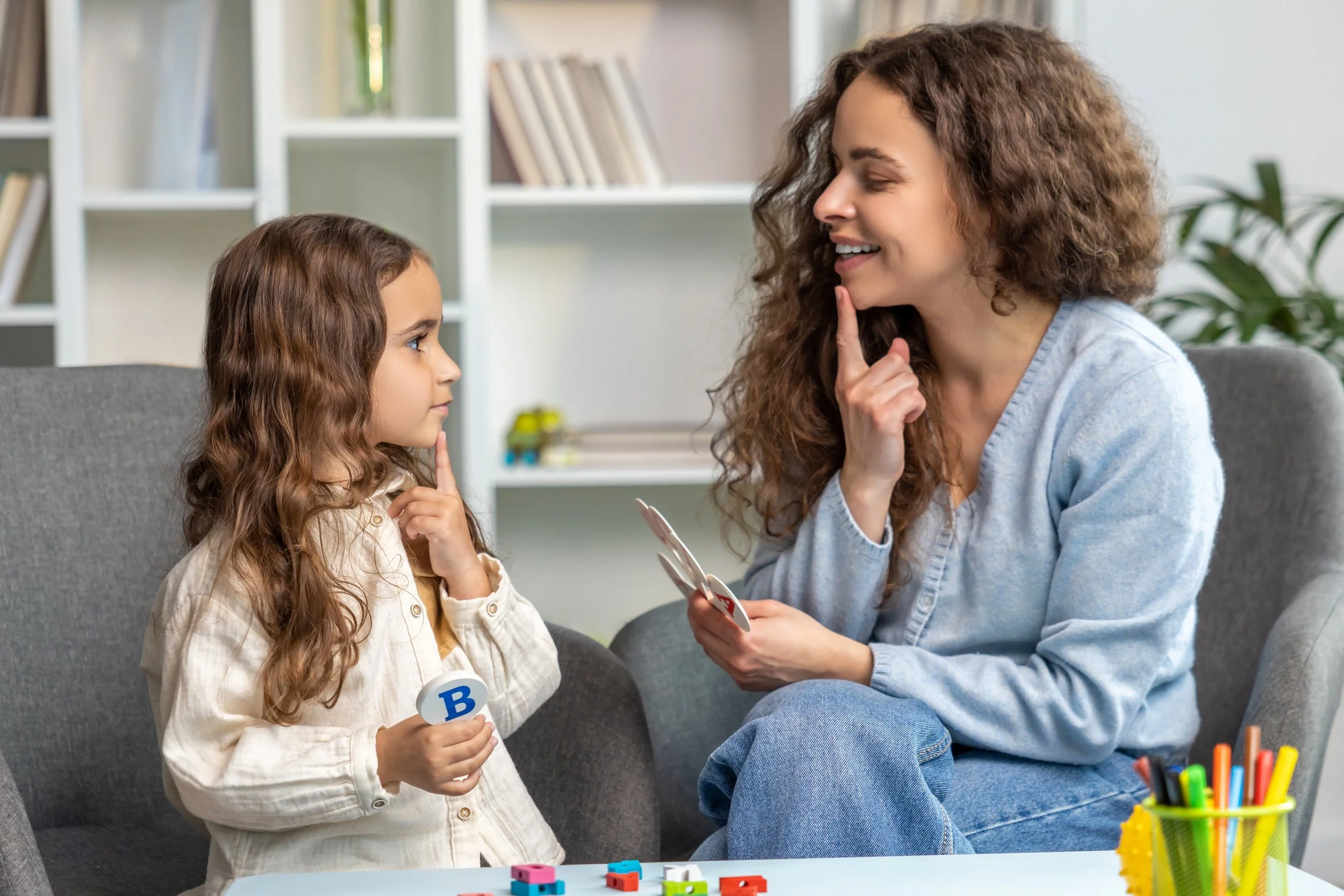Speech therapist helping a toddler improve speech and language skills