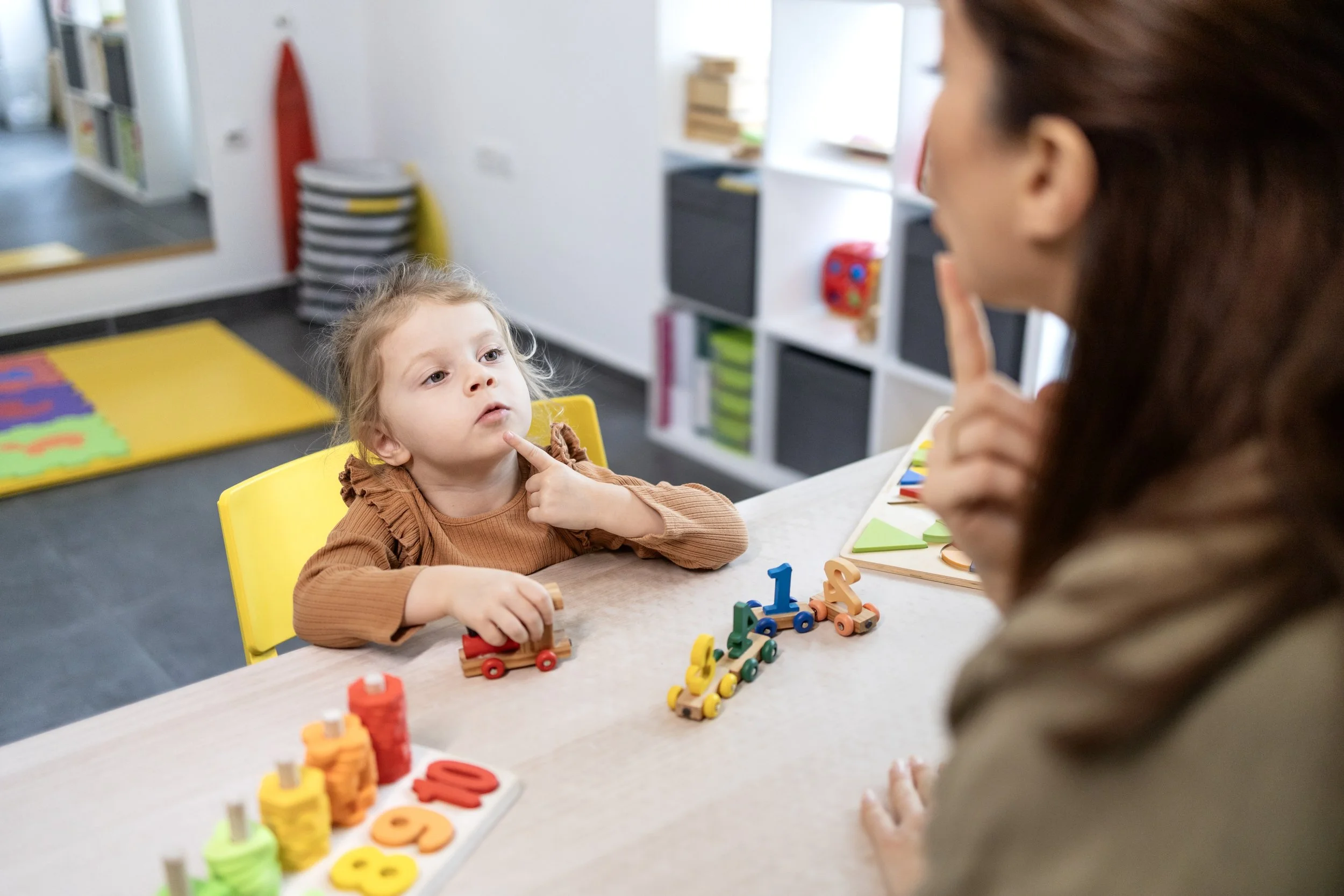Speech therapist providing speech therapy to a young child during a play-based session