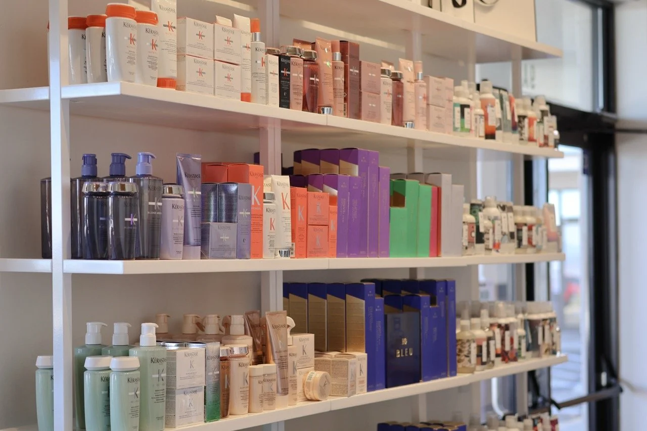 Store shelves filled with various hair care products, including shampoos, conditioners, and treatments in different colored bottles and boxes.