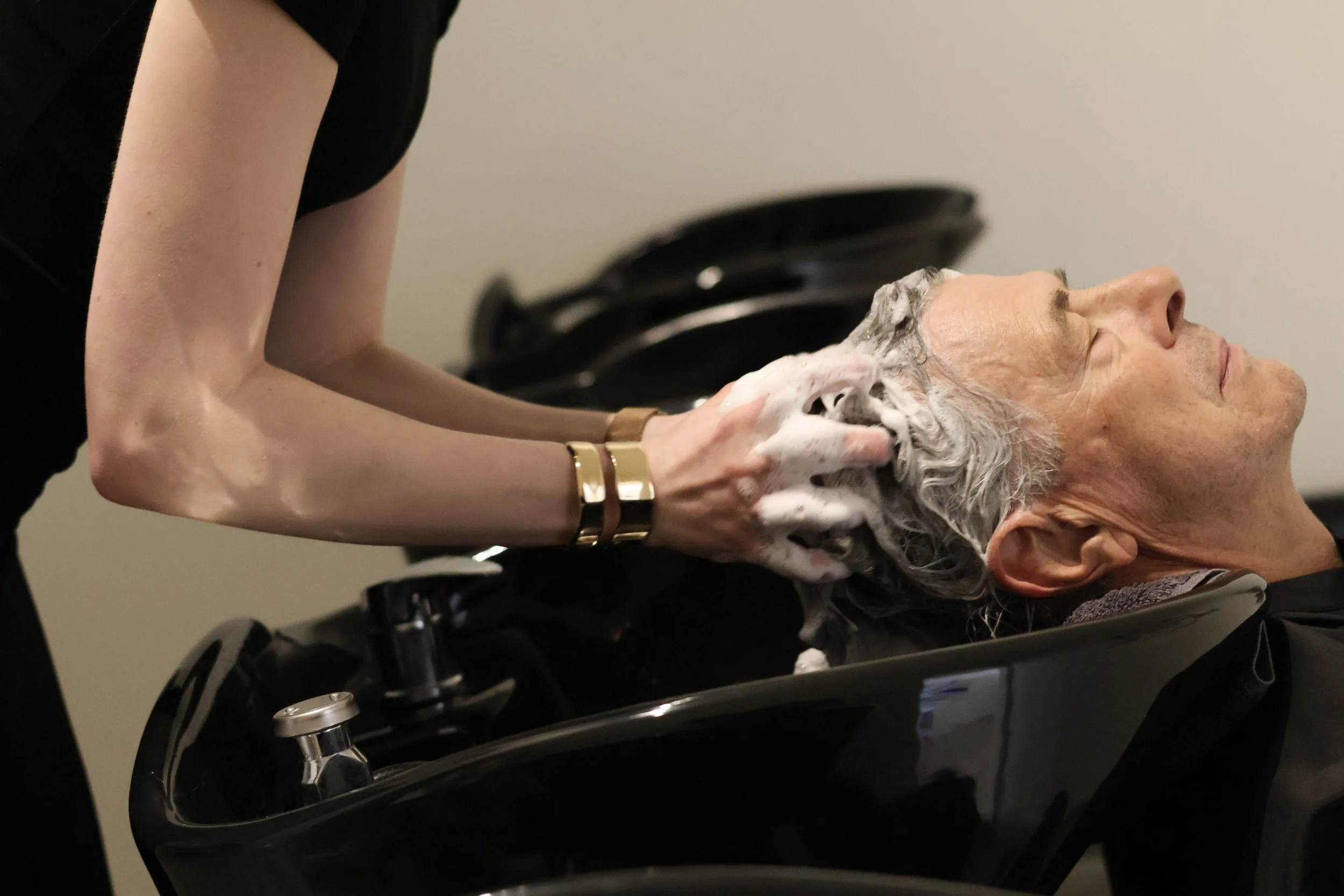 Hair stylist shampooing a client’s hair at Mesh Hair Studio