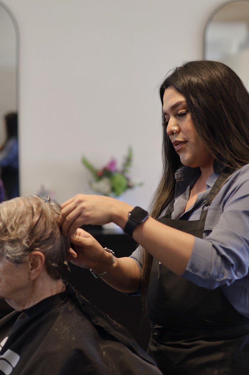 Women styling an elderly woman's hair in a salon.