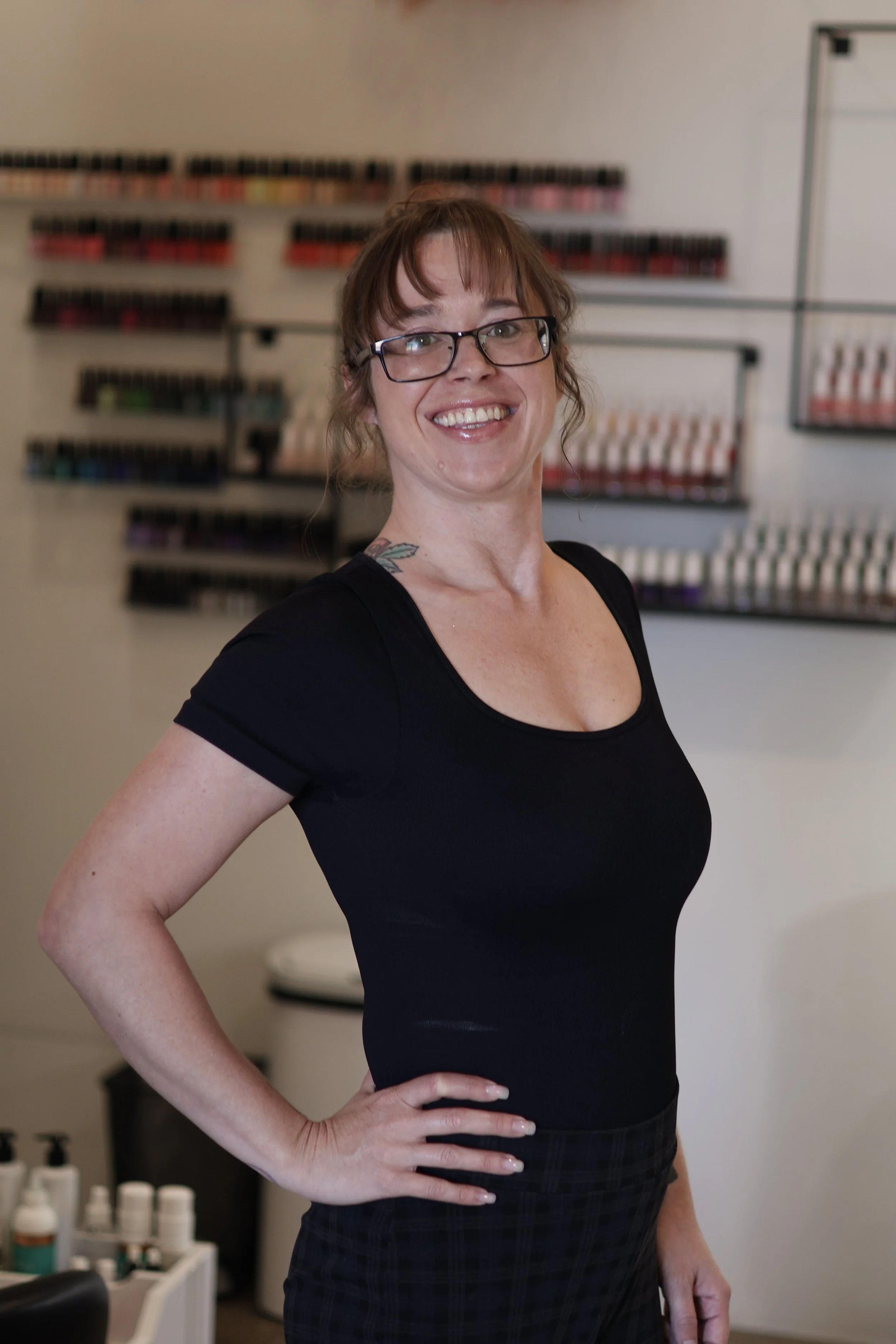 Multiple bottles of light pink and nude nail polish lined up on a shelf.