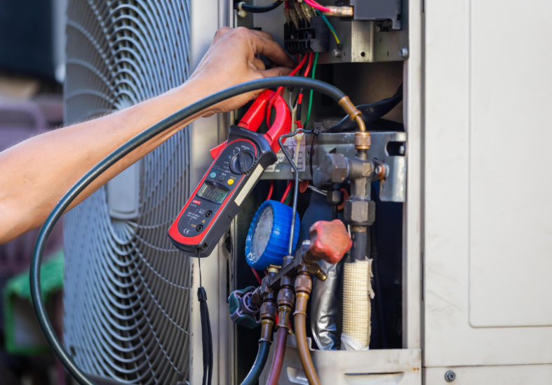 Technician using a multimeter to test and troubleshoot an air conditioning unit or HVAC system.
