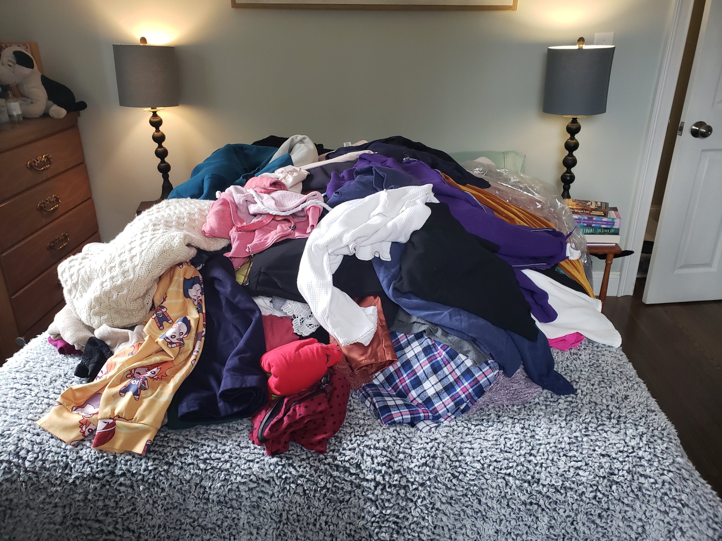 Large clothing pile on bed