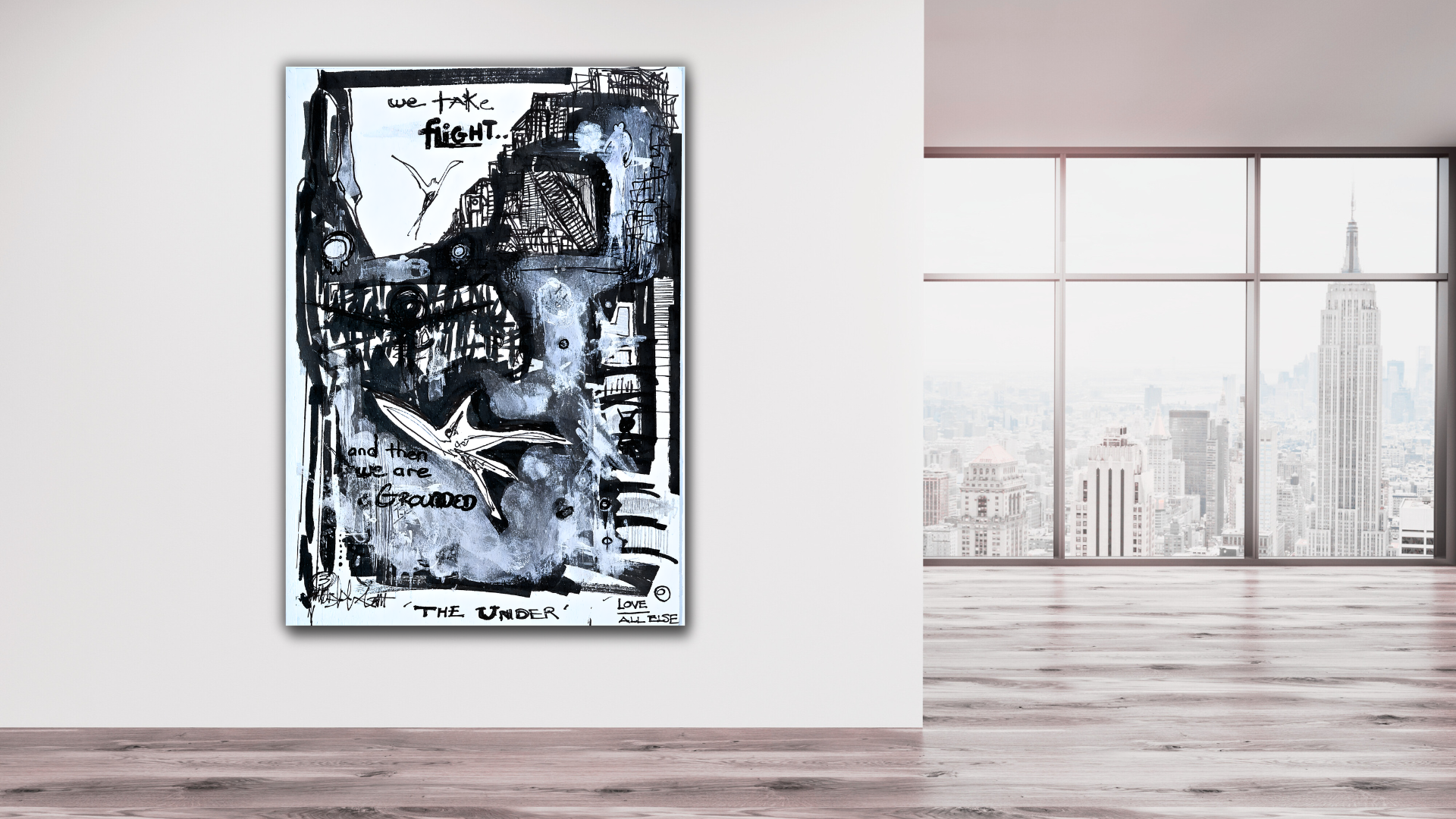 Black and white abstract artwork with handwritten phrases 'we take fight...' and 'and then we are grounded' displayed on a white wall in a modern room with large windows showing a city skyline, including the Empire State Building.