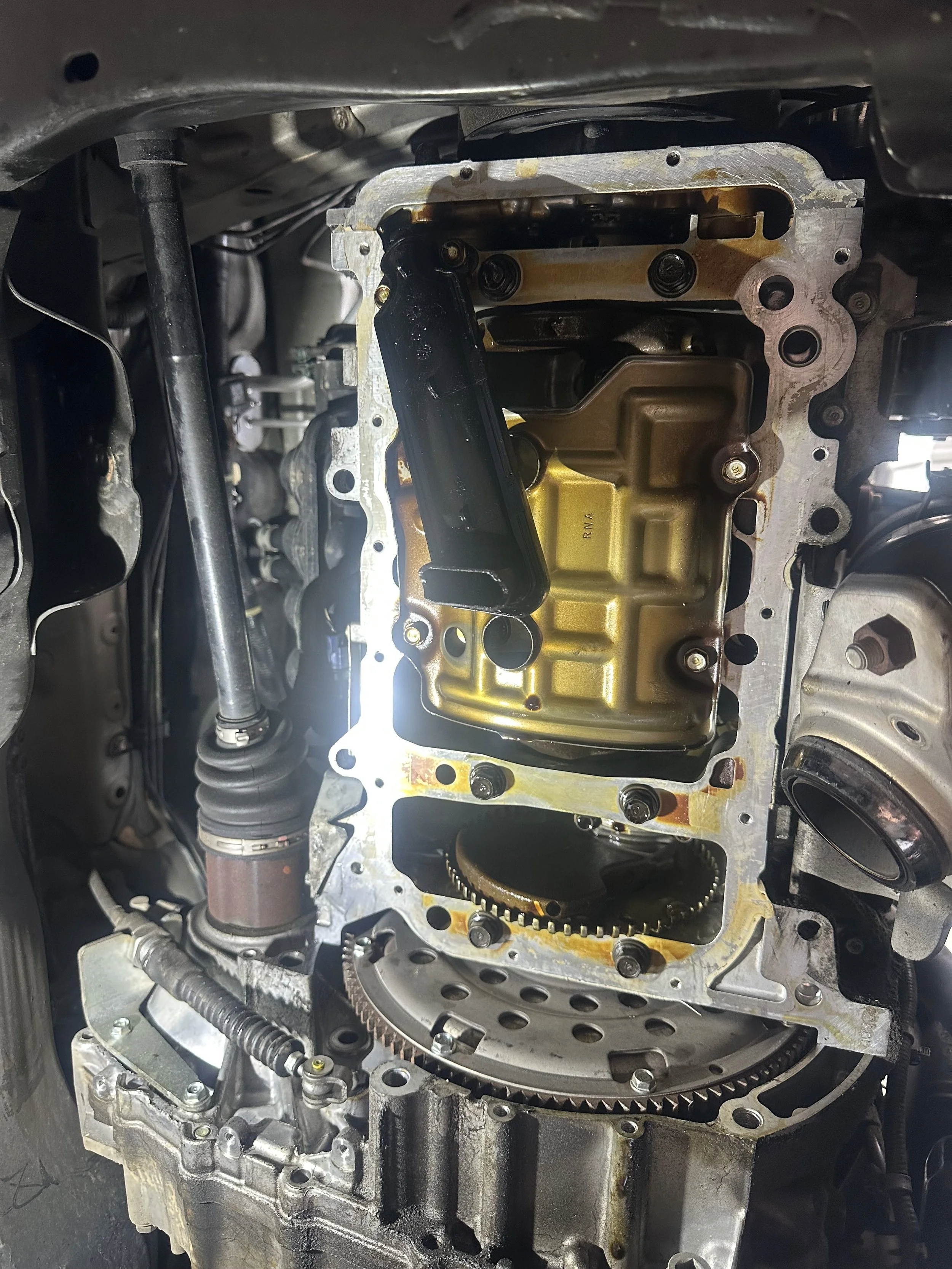 An engine with the valve cover removed, showing internal components like gears and oil passages.