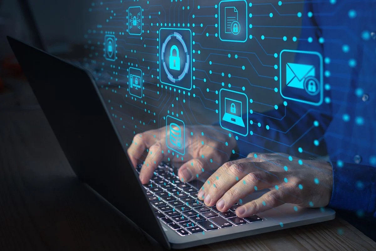 Person typing on a laptop with digital security icons, such as padlocks and encrypted email, floating above the keyboard.