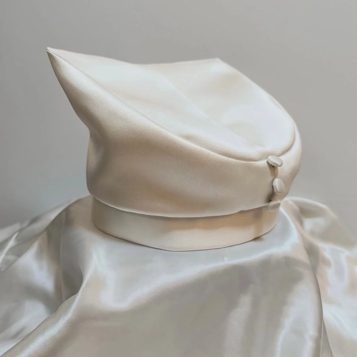Center front dart and covered buttons, mimicking bridal overcoat. 