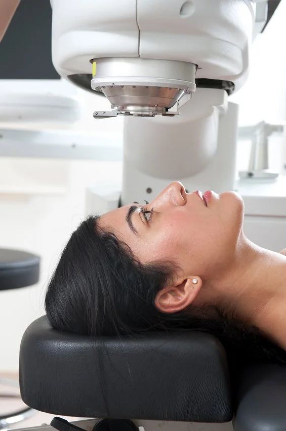 Woman lying down during a medical scan or MRI procedure in a clinical setting.