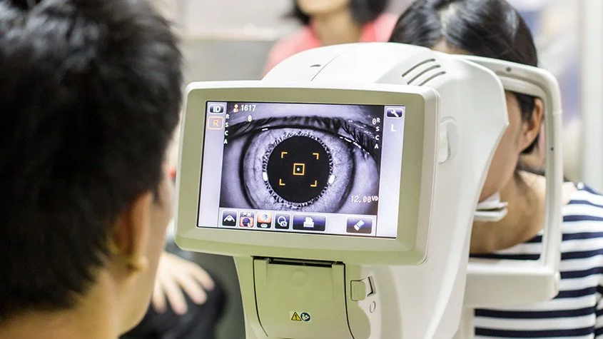 Person getting eye exam with a slit lamp and digital imaging of the eye.