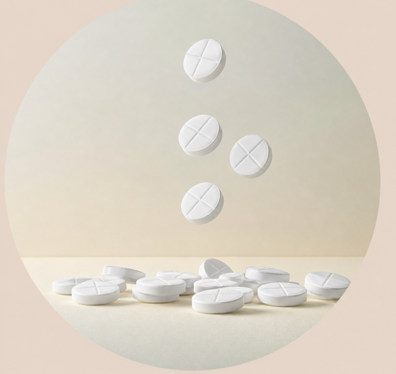 White tablets with a cross score design, some are falling and others are scattered on a beige surface against a neutral background.