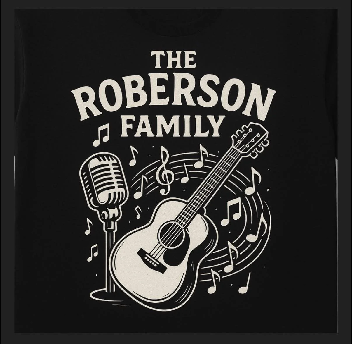Black T-shirt with white graphic text and images. The text reads 'The Roberson Family' above musical instruments. The graphic includes a microphone, an acoustic guitar, and musical notes.
