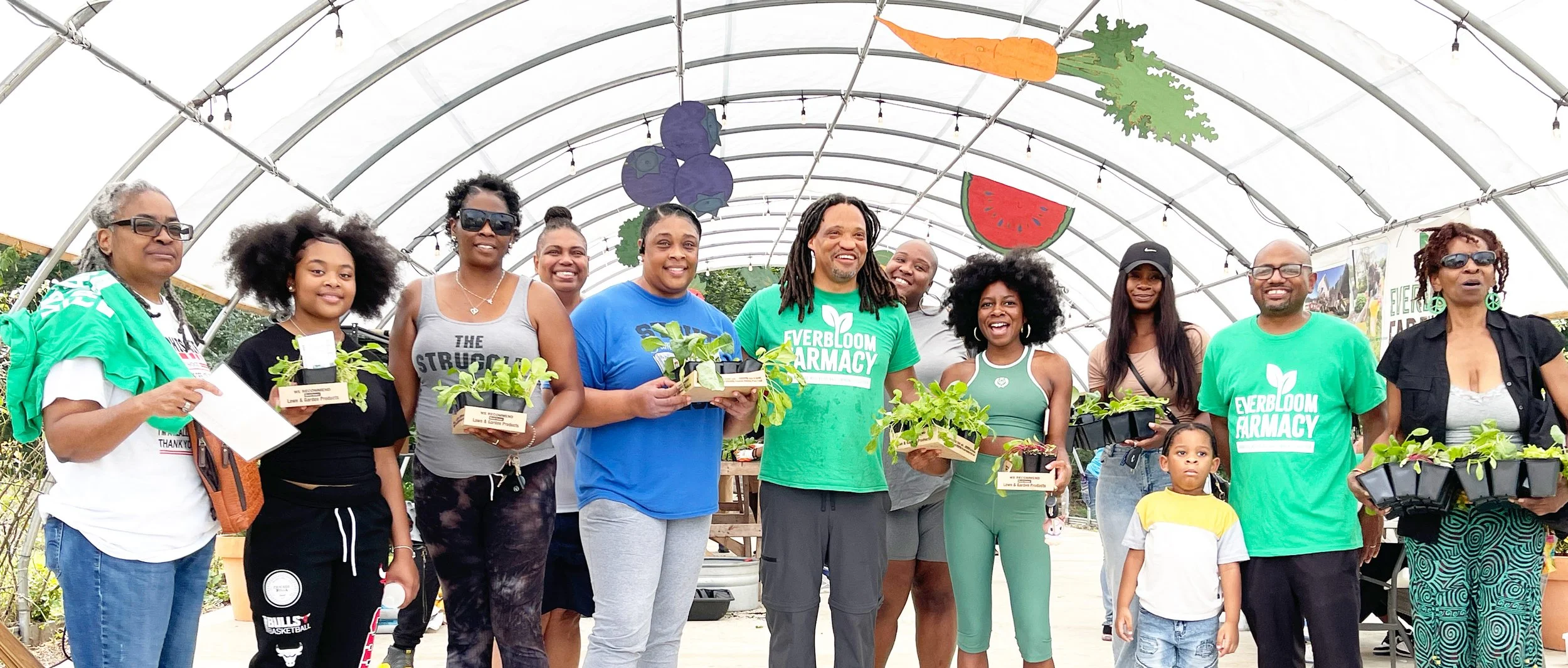 Everbloom Farmacy Executive Director Kenneth Anderson smiles with Grow Partners and volunteers at a seedling distribution at the farm.