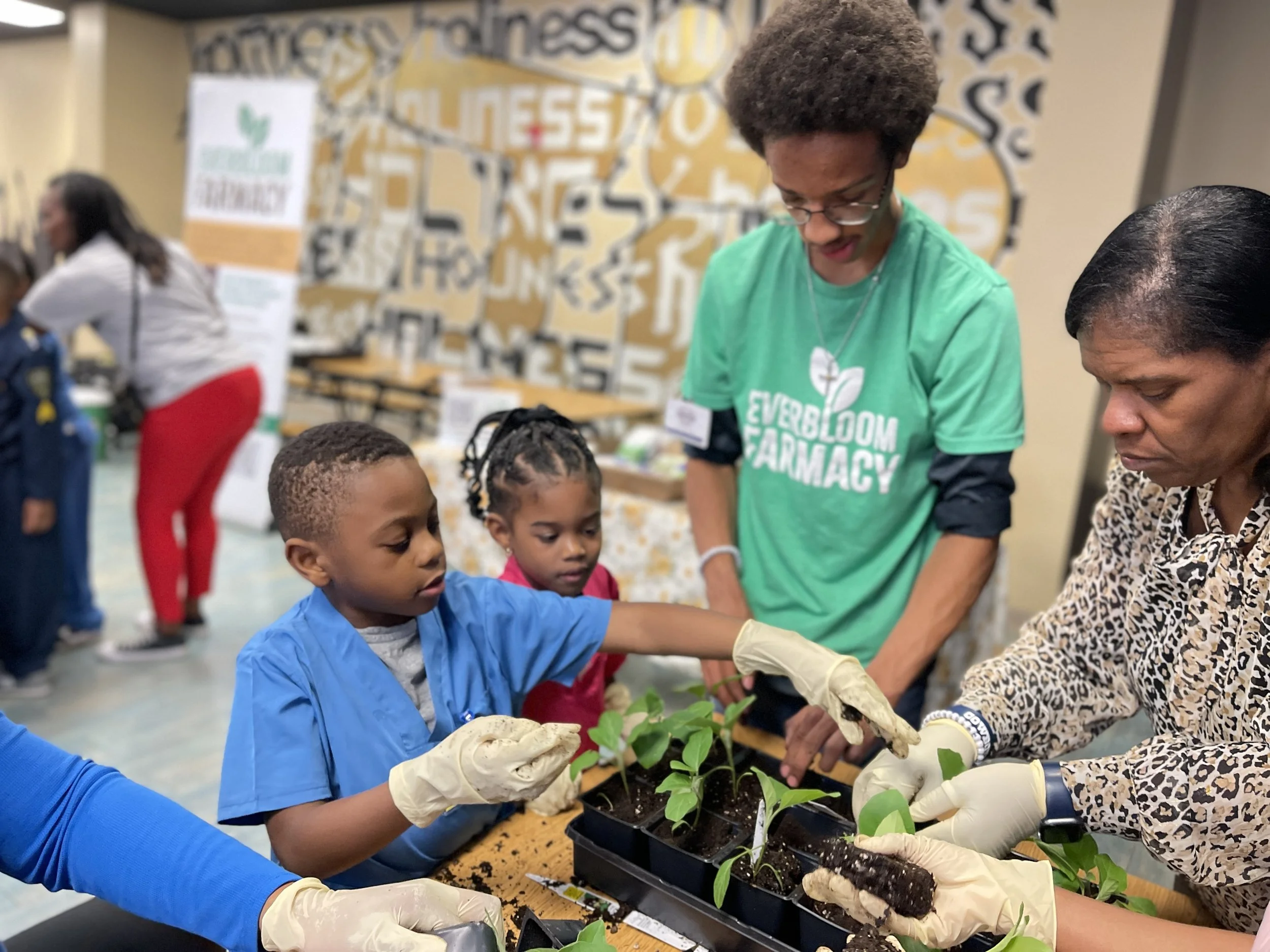 An Everbloom volunteer teaches students to sow seeds at Breath of Life Preparatory Academy.