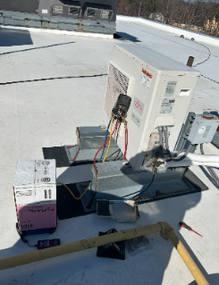 Equipment setup on snow with electrical components and wires connected to an outdoor device.