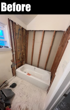 Bathroom renovation with exposed wall studs and a white bathtub installed, unfinished walls, and construction tools on the floor.
