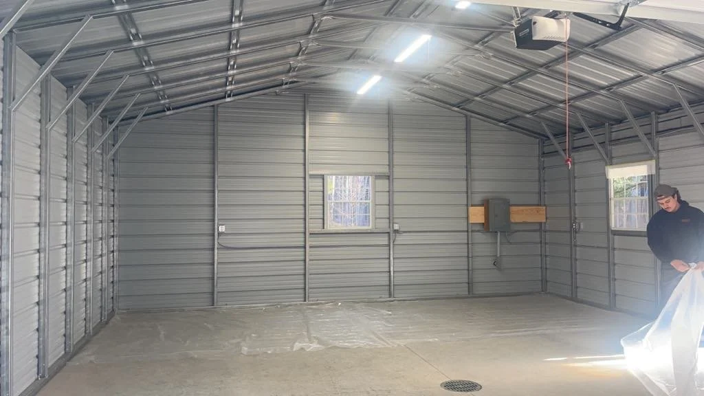 Empty metal garage with two small windows before insulation services are completed