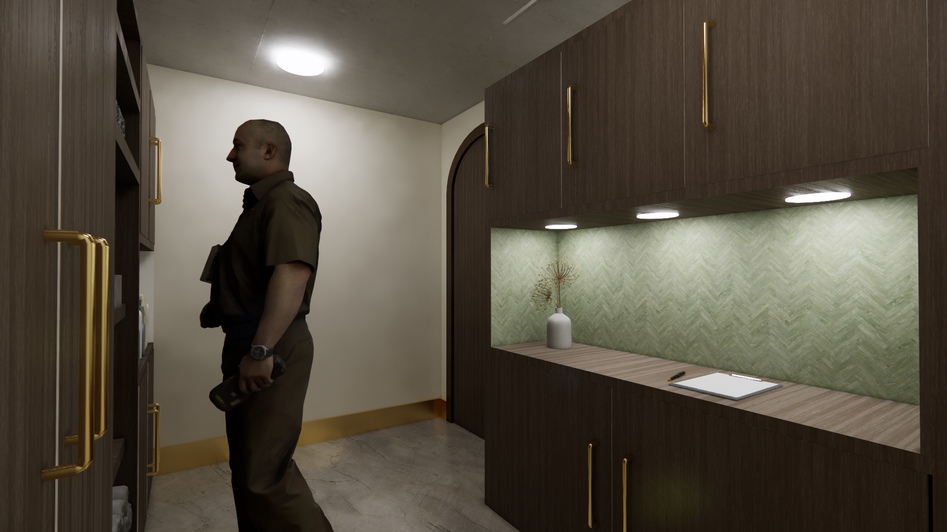 A man in brown uniform standing in front of a wooden cabinet in a room with a beige wall, marble floor, and green patterned backsplash, holding a device in his hand and looking at the cabinet.