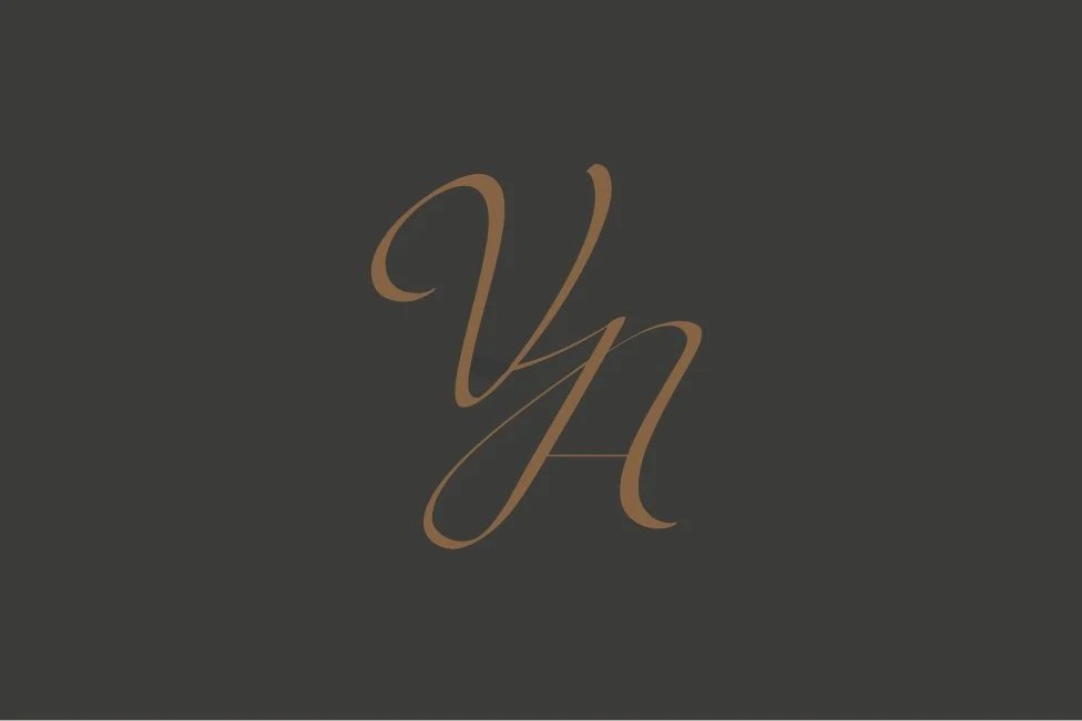 Elegant white cursive initials 'YH' on a dark gray background.