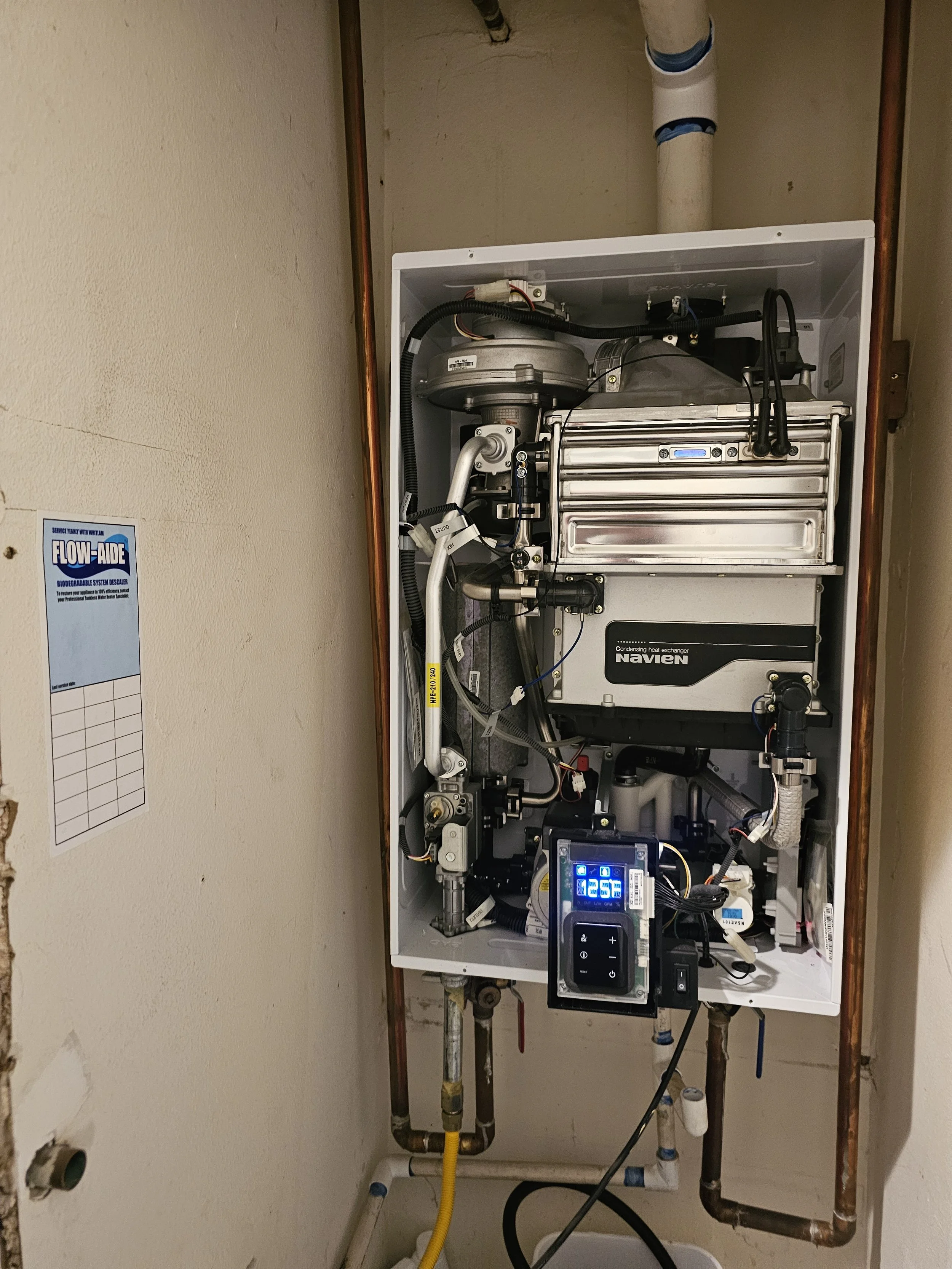 Internal components of a Navien tankless water heater system being serviced and maintained by Emerald Systems, ensuring optimal performance for East Bay homeowners.
