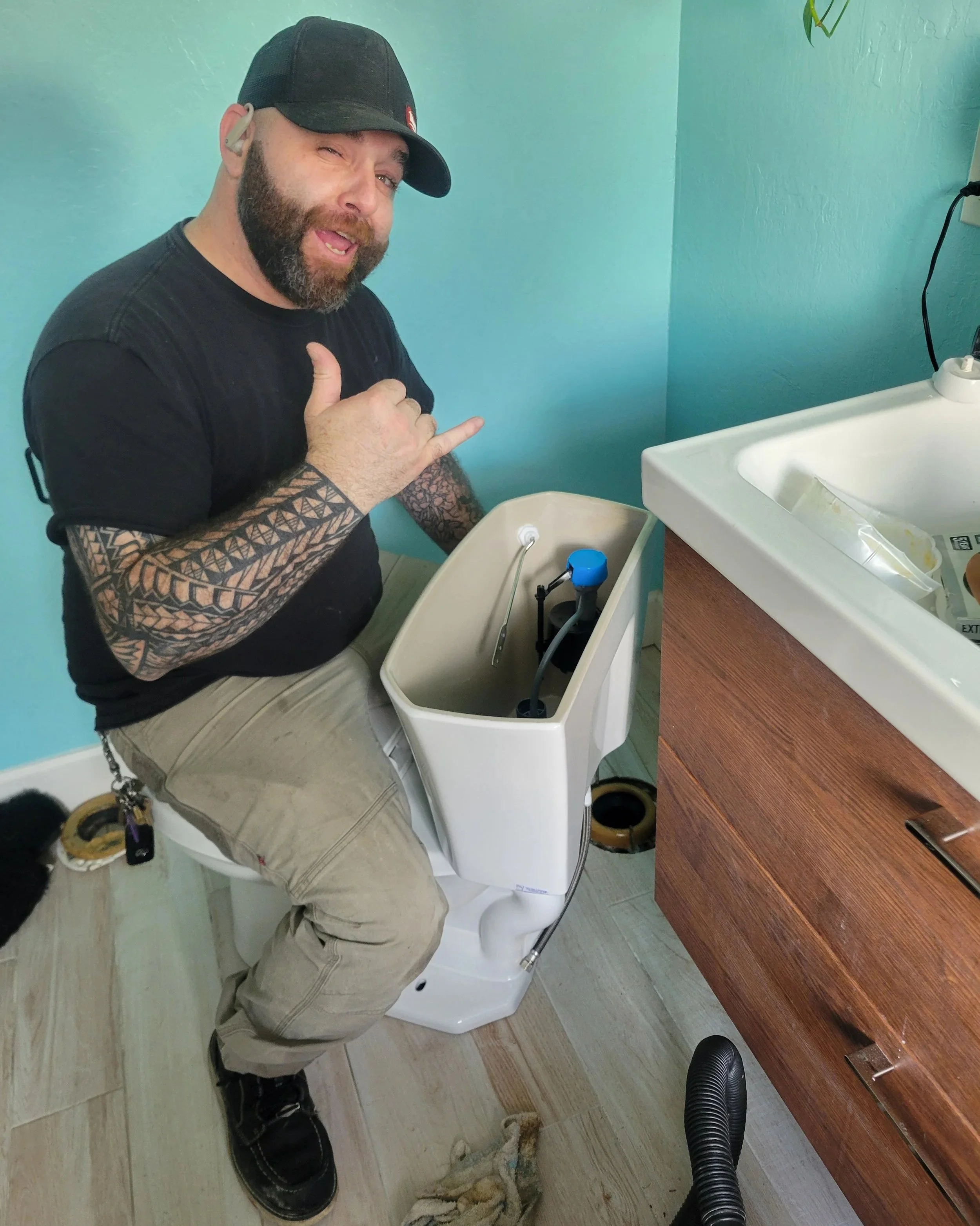 Daniel Davis of Emerald Systems repairing toilet tank components in residential bathroom, professional toilet repair service in East Bay