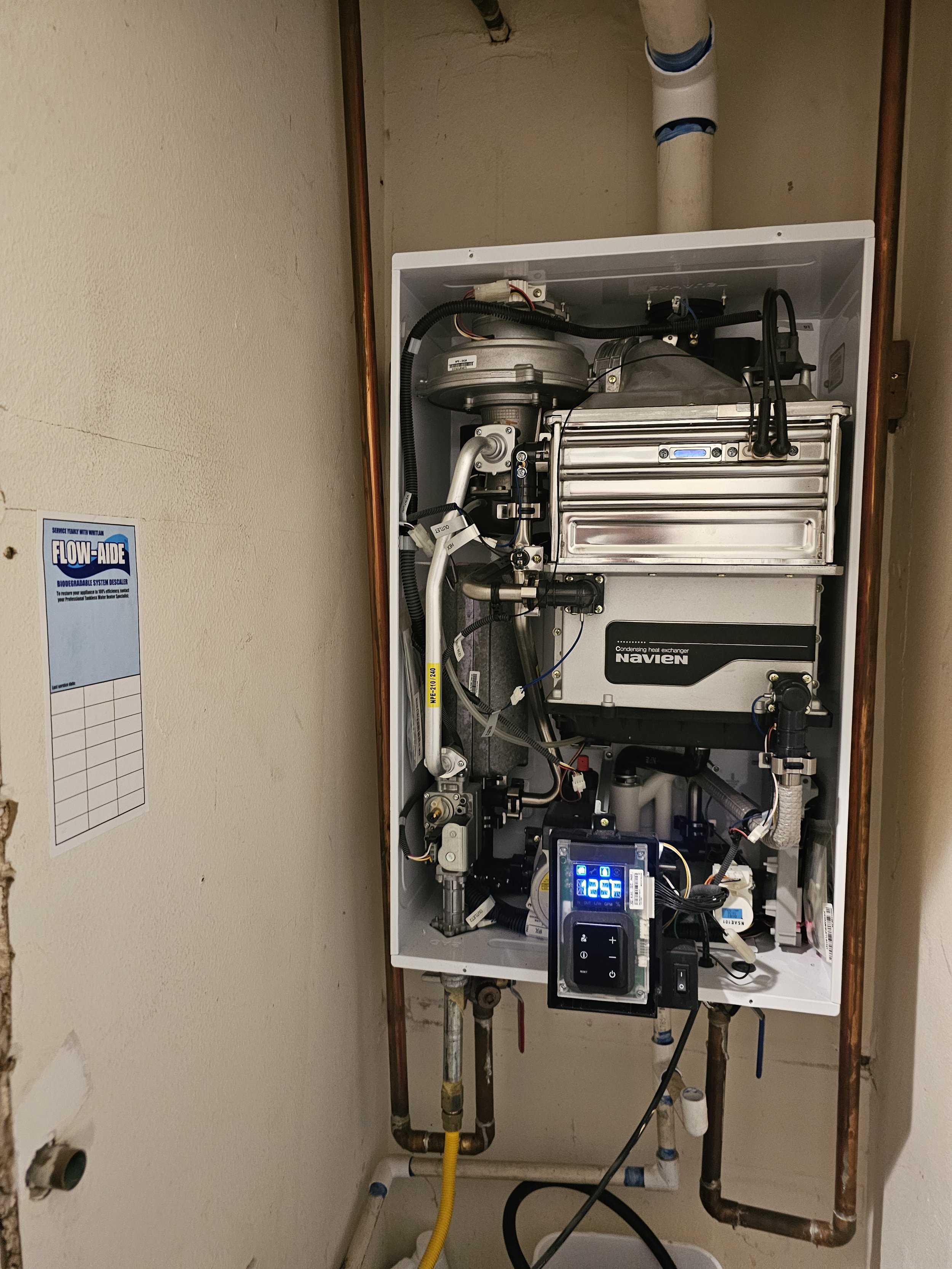 Internal components of a Navien tankless water heater system being serviced and maintained by Emerald Systems, ensuring optimal performance for East Bay homeowners.