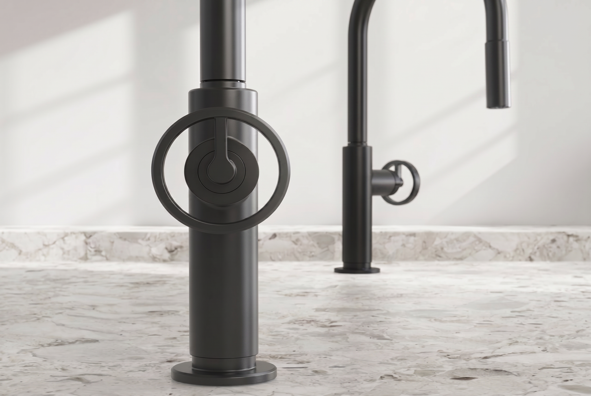 Matte black kitchen faucet with circular handle and separate pull-down sprayer on a marble countertop