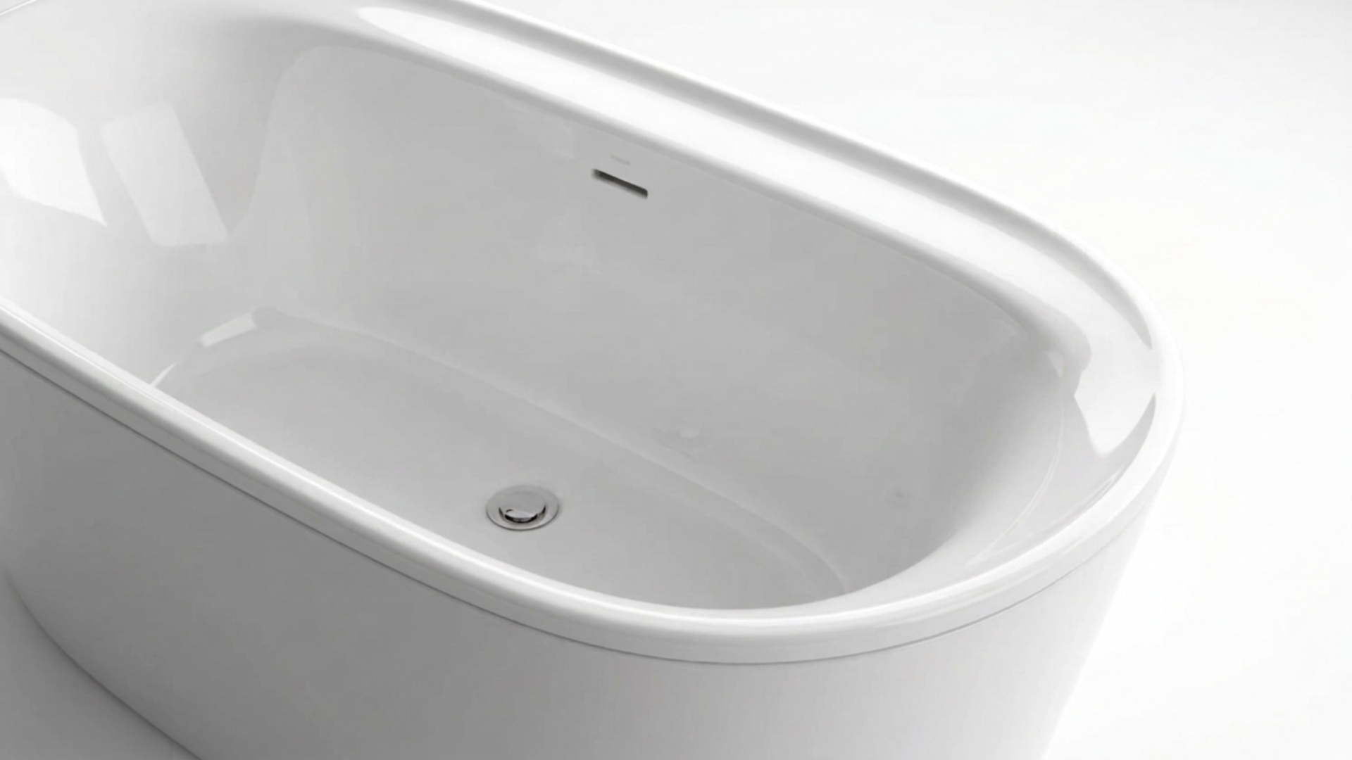 A white bathtub with a smooth curved design, located in a bright bathroom with white walls.