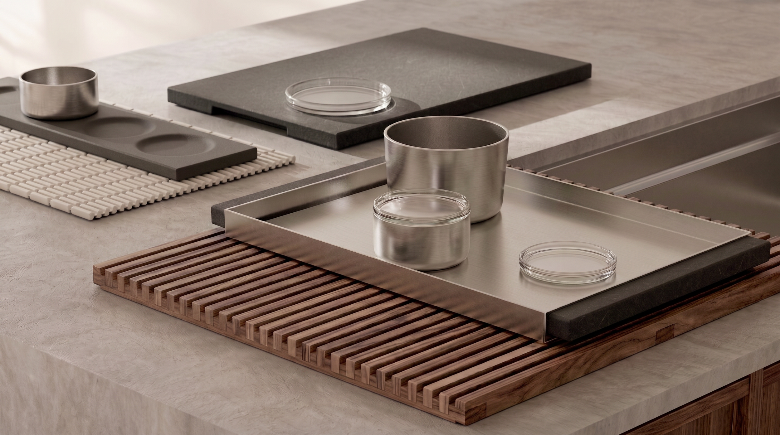 Various kitchen countertops and cutting boards with metal and glass containers, some placed on wooden and rubber mats.