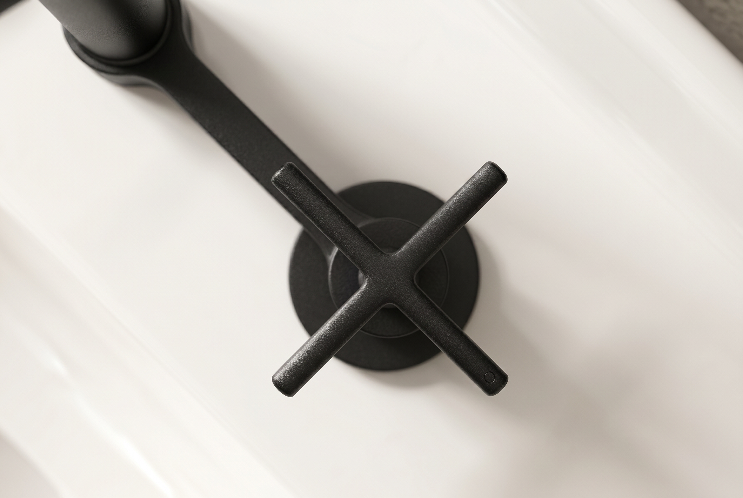 Close-up of a black faucet handle on a white sink or countertop.