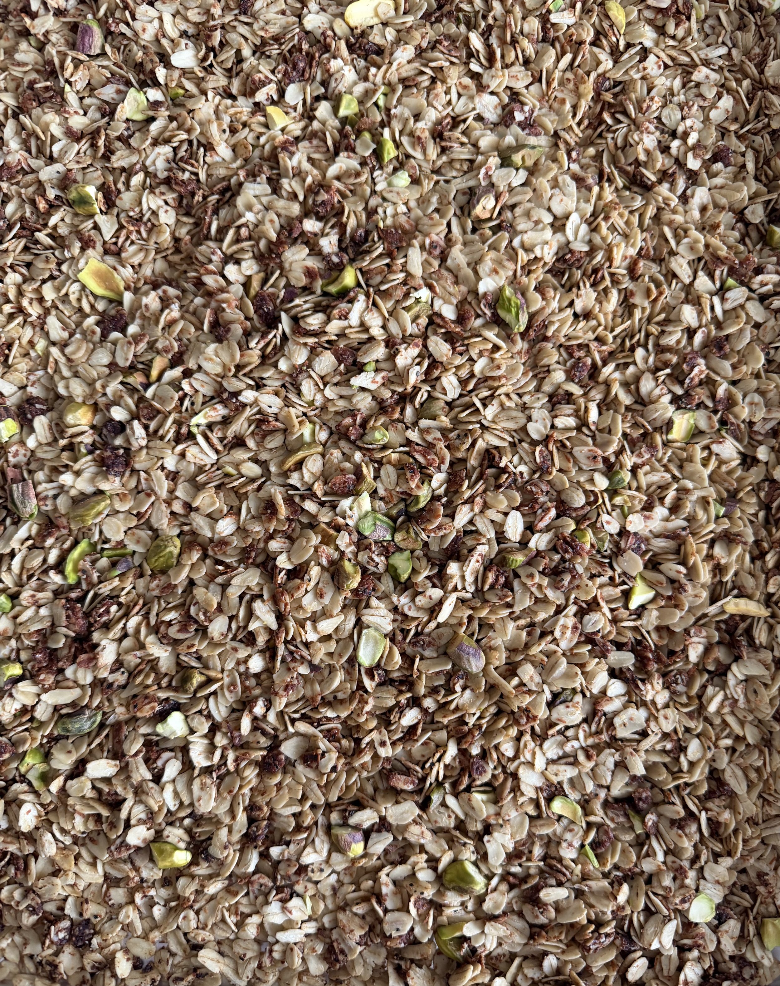 Close-up of a mixture of chopped nuts and seeds, including sunflower seeds, pumpkin seeds, and small bits of dried fruit.