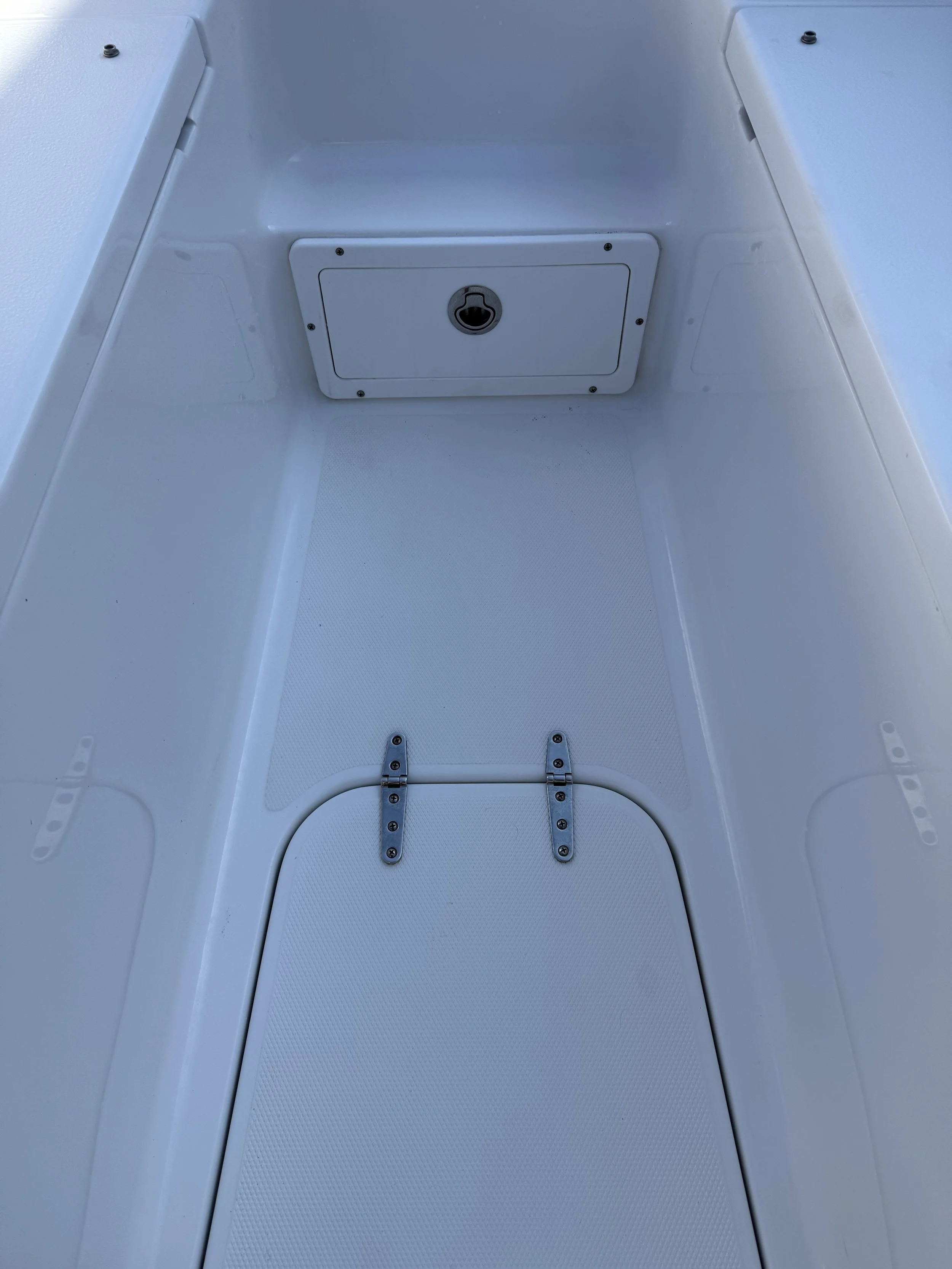 Interior of a boat console with a drain and mounting hardware.