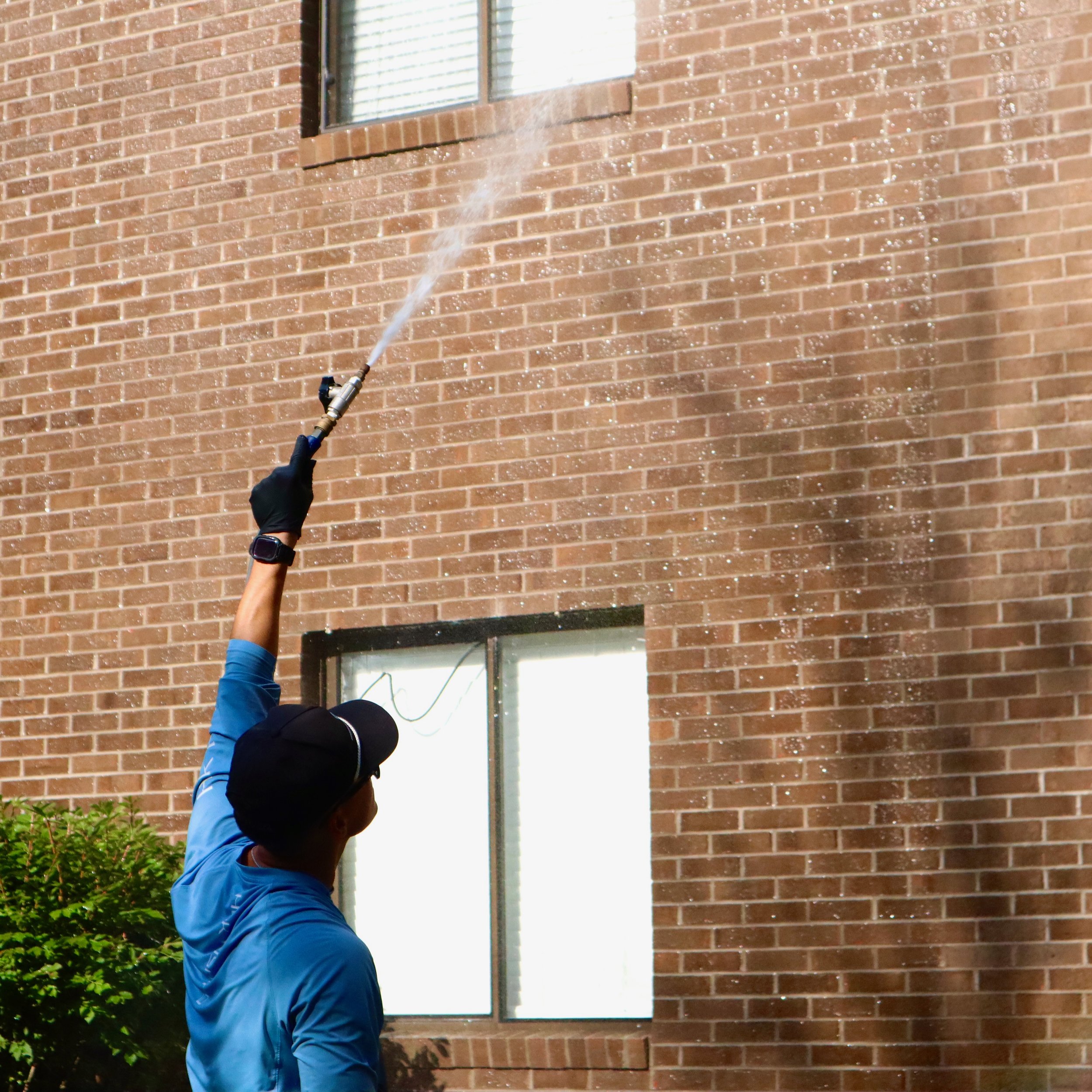 Person power washing a commerical building 
