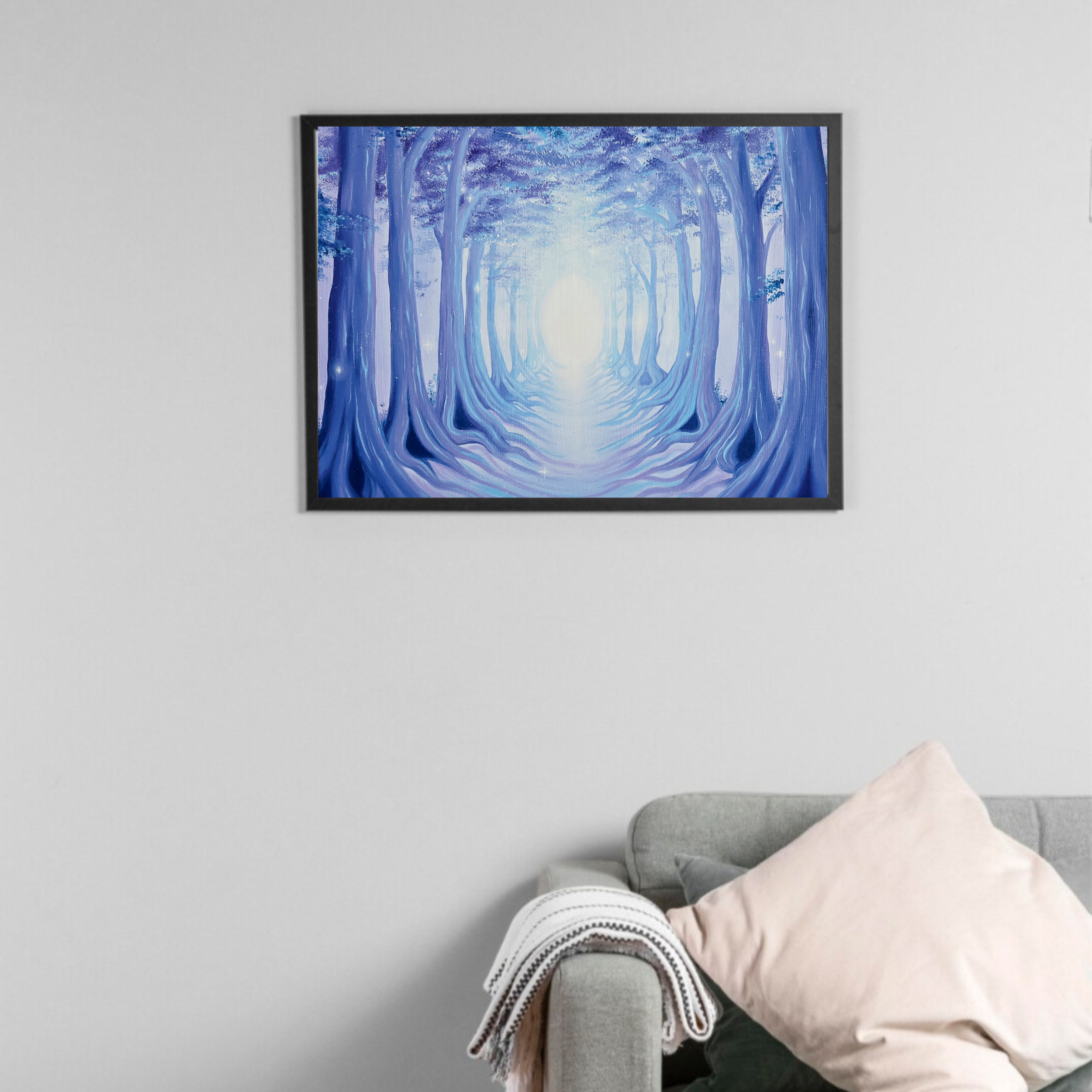 Overhead view of a person standing on a gray carpeted floor, wearing beige sneakers with black laces, gray pants, and a beige coat, looking at a wall-mounted framed painting of a blue-toned forest scene.