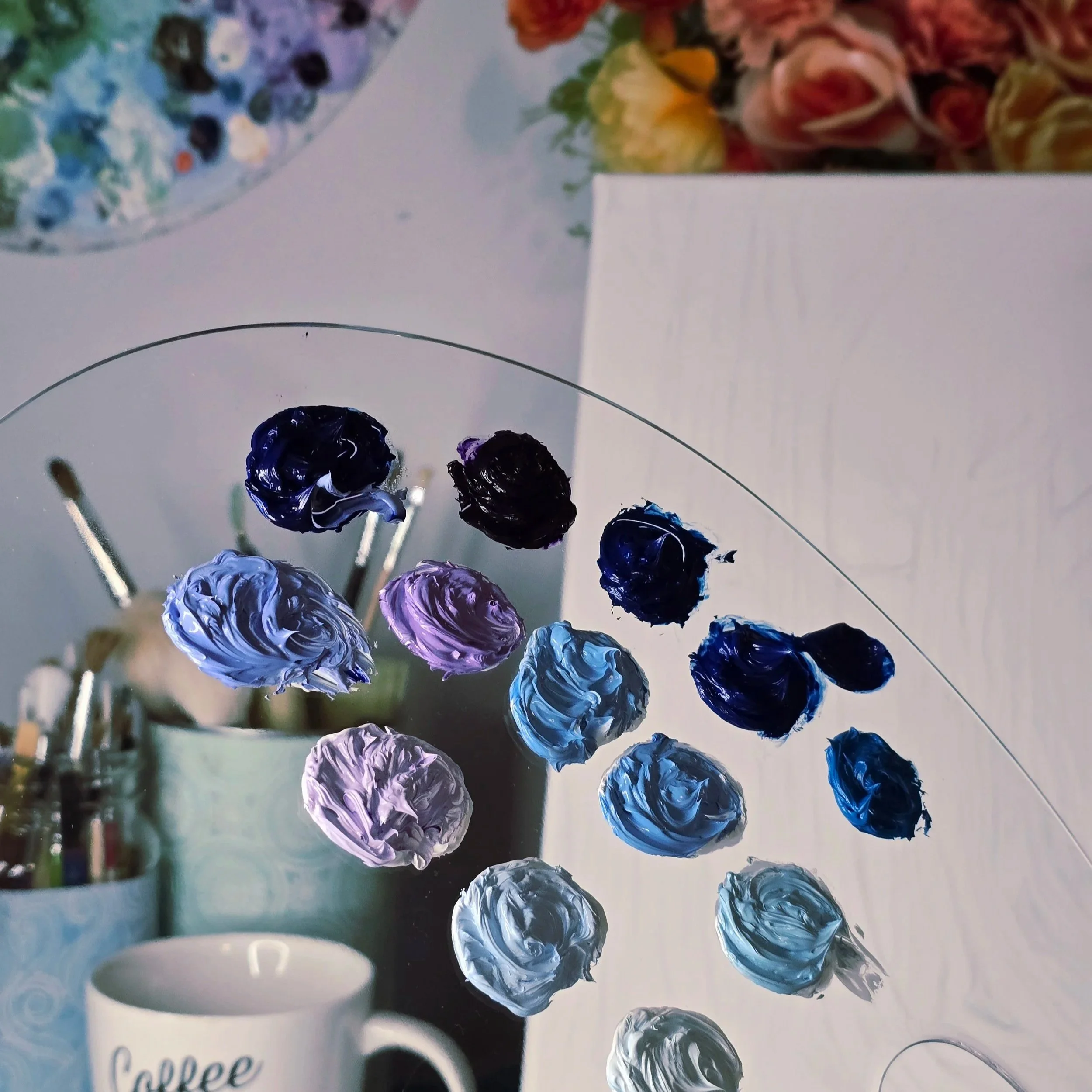 Close-up of a paint palette with oil paint in shades of blue, purple, black, periwinkle, and indigo. Art studio in Brandon Manitoba. Nature art, surreal art, ethereal art, eclectic art, dreamlike art, forest art, custom artwork Manitoba