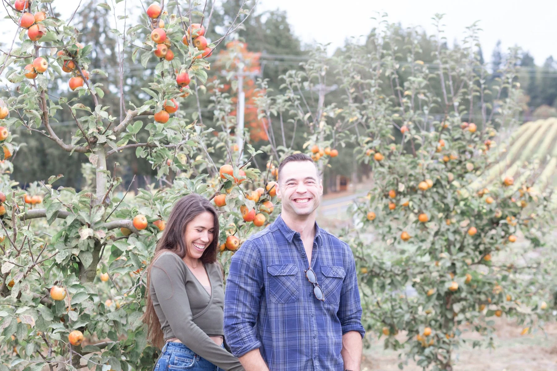 happy couple in orchard in fall