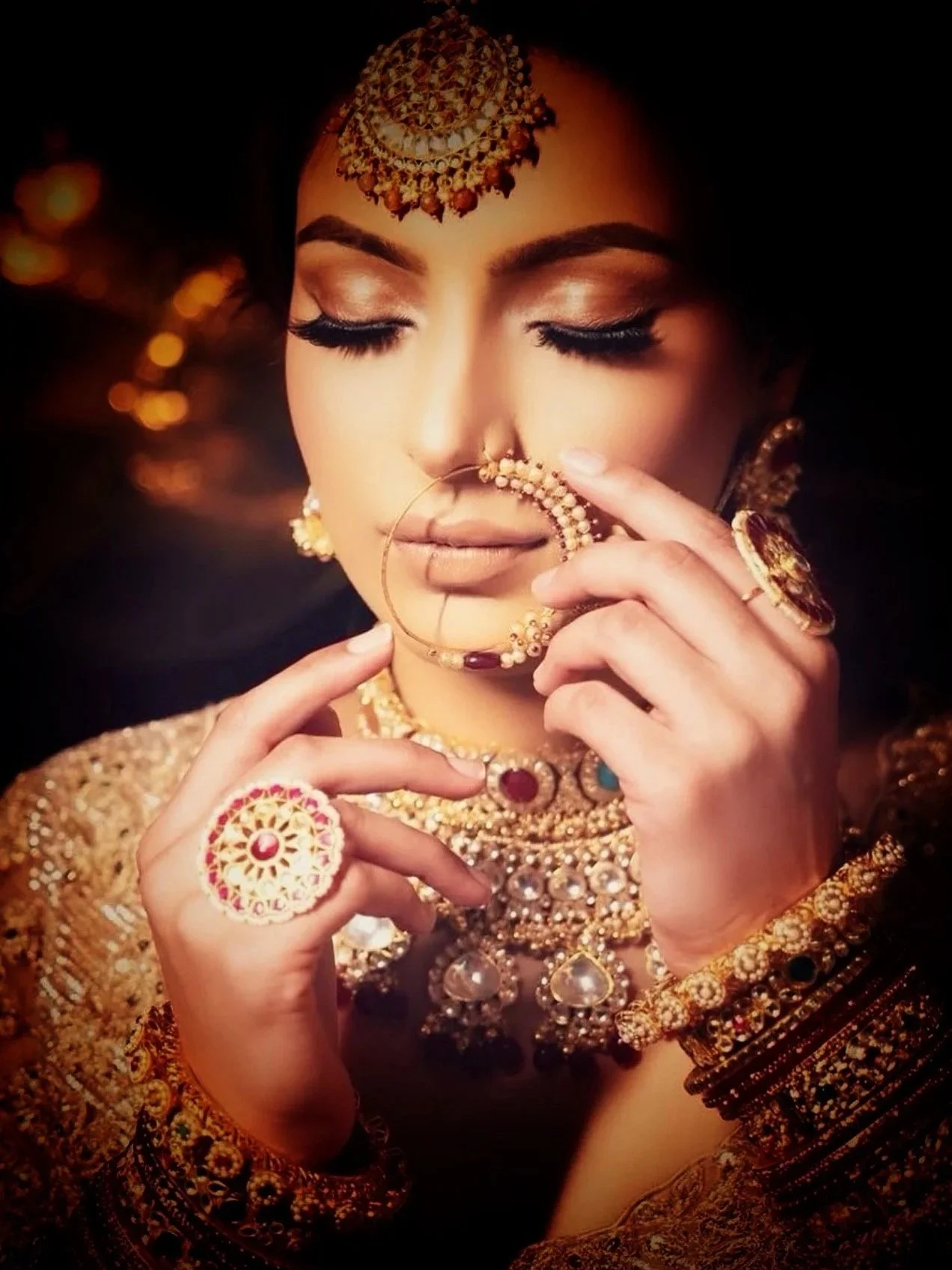 Close-up of Indian bride wearing kundan bridal jewelry including nath nose ring and layered necklace for wedding ceremony.