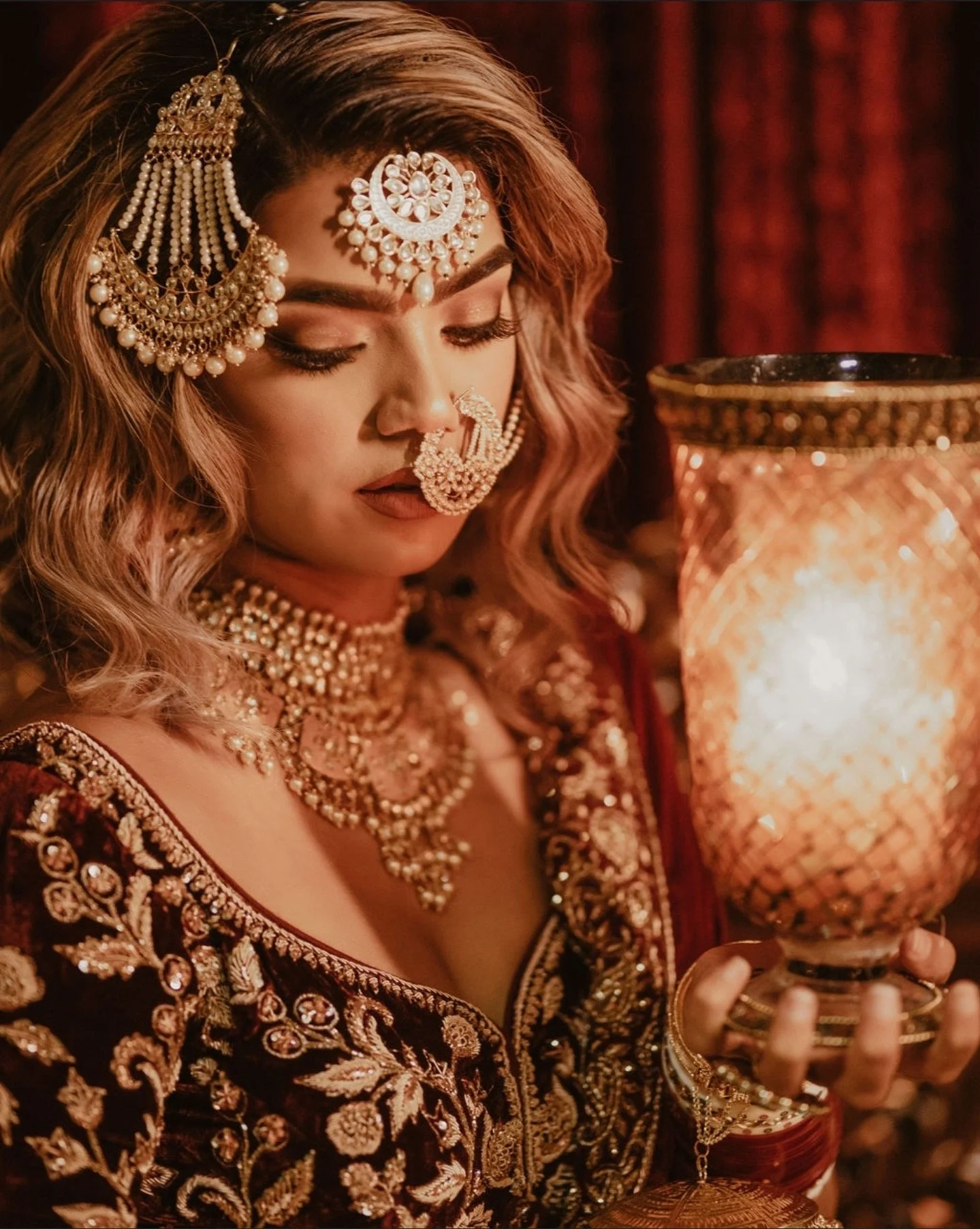 Indian bride wearing polki maang tikka and bridal jewelry styled with red wedding outfit.