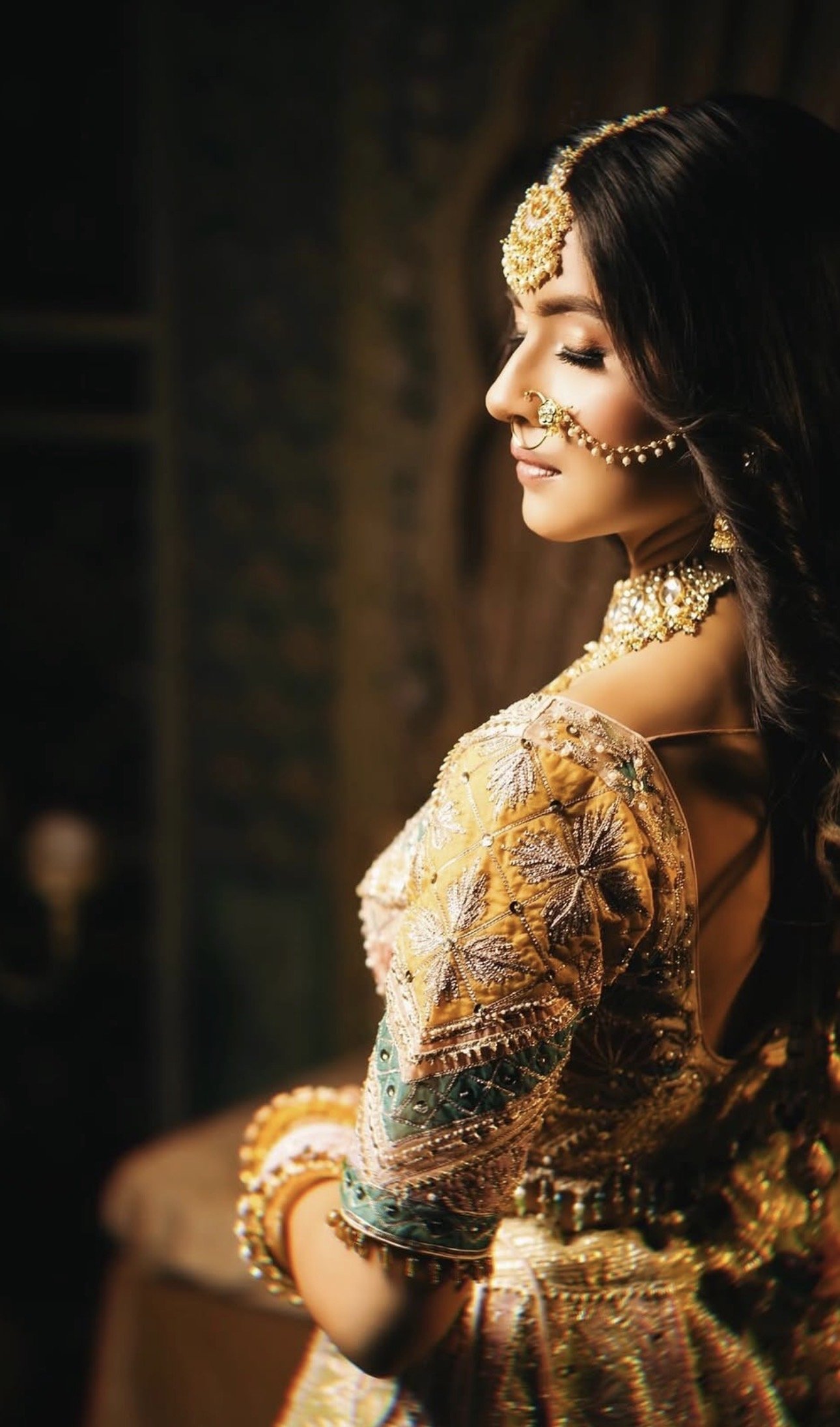 Indian bride in side profile wearing polki and kundan bridal jewelry styled for wedding look.