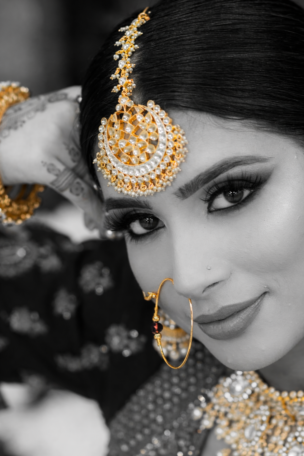 Close-up of Indian bride wearing kundan maang tikka and nath nose ring styled for bridal look.