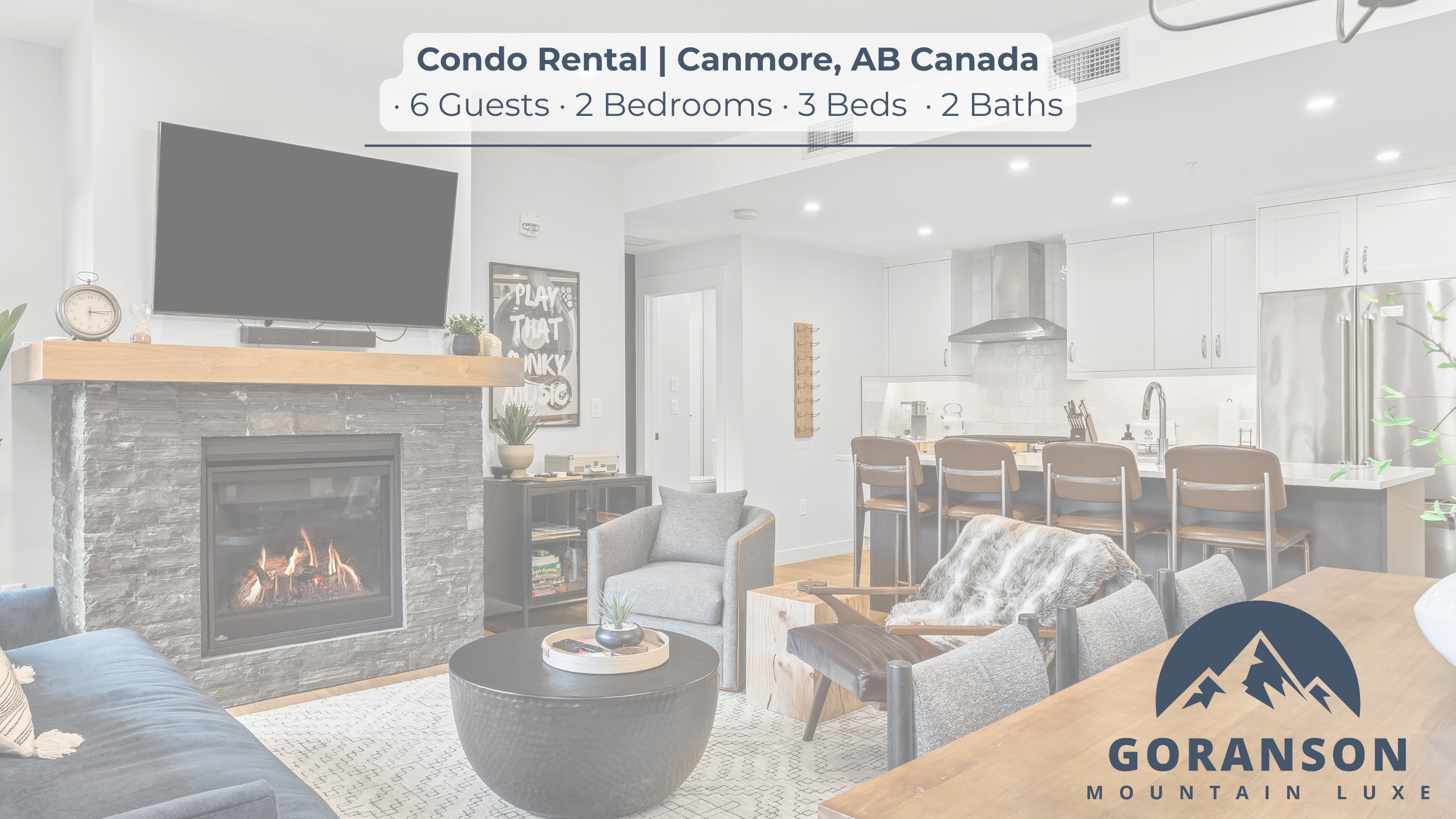 Living room and kitchen of a condo for air bnb rent in Canmore, AB, Canada, with a fireplace, TV, gray armchair, dining table, kitchen island, and barstools, in a modern and bright space.