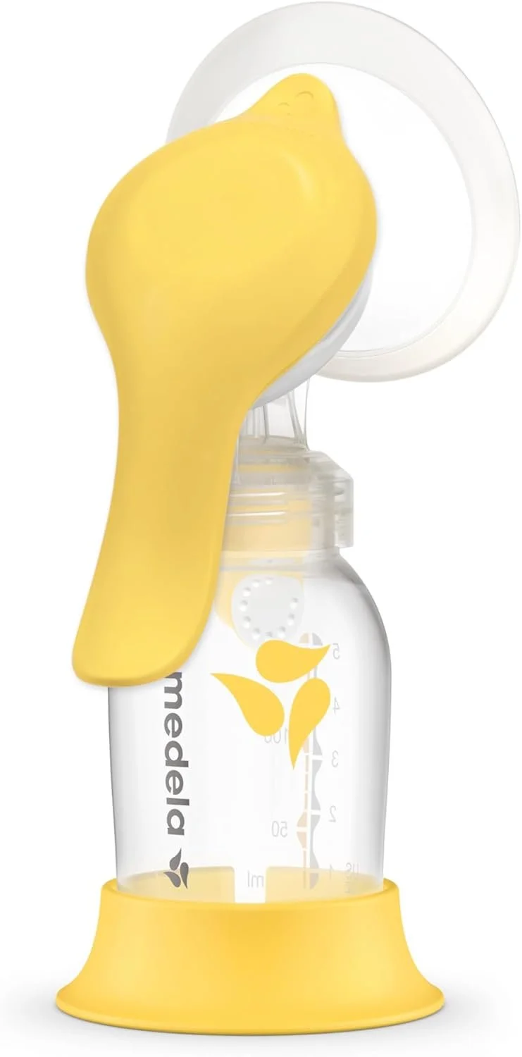 A yellow silicone hand-shaped bottle holder attached to a baby bottle with a yellow base and a shield with a handle, designed for feeding babies.