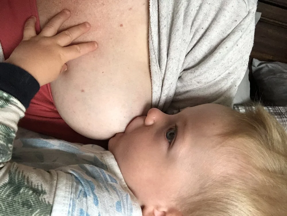 Child breastfeeding from a woman.